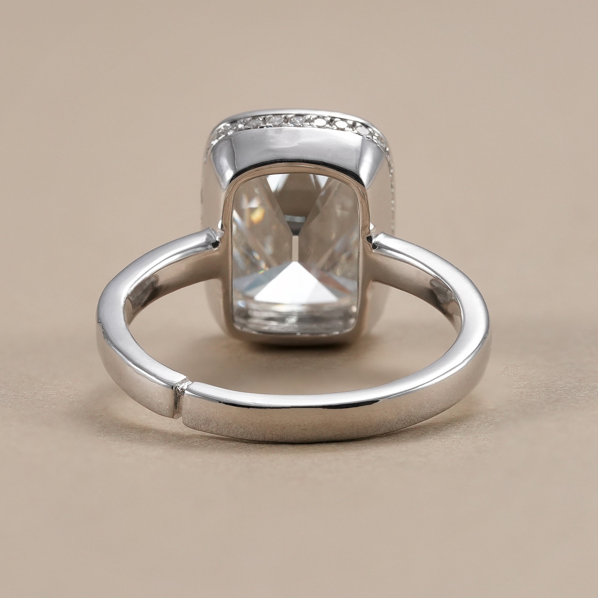 Modern cushion engagement ring with bezel set lab diamond.