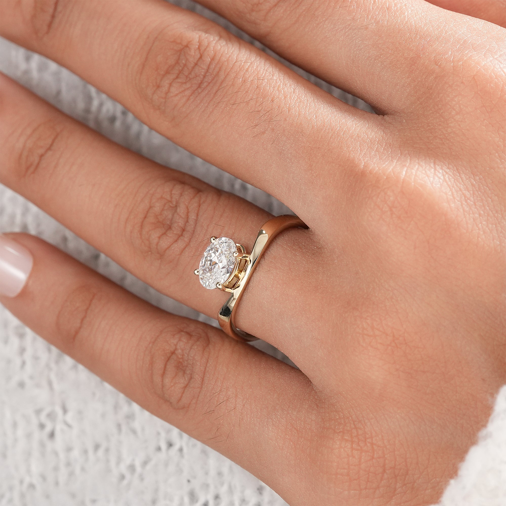 Four prong oval solitaire diamond ring in yellow gold.