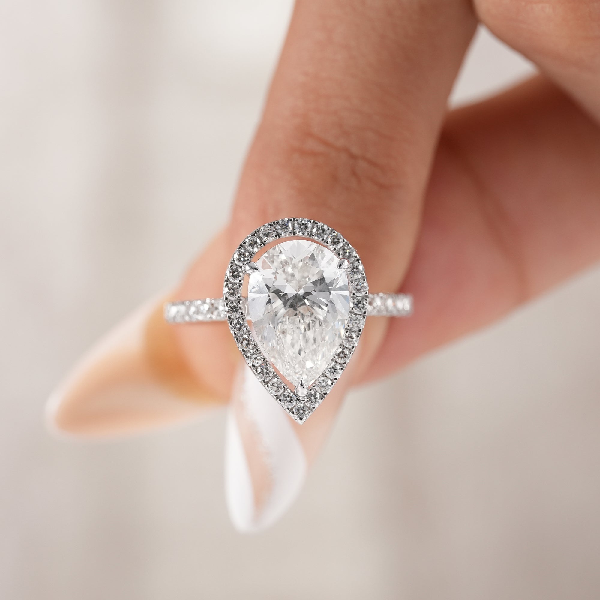 Handmade pear diamond engagement ring with pavé setting.