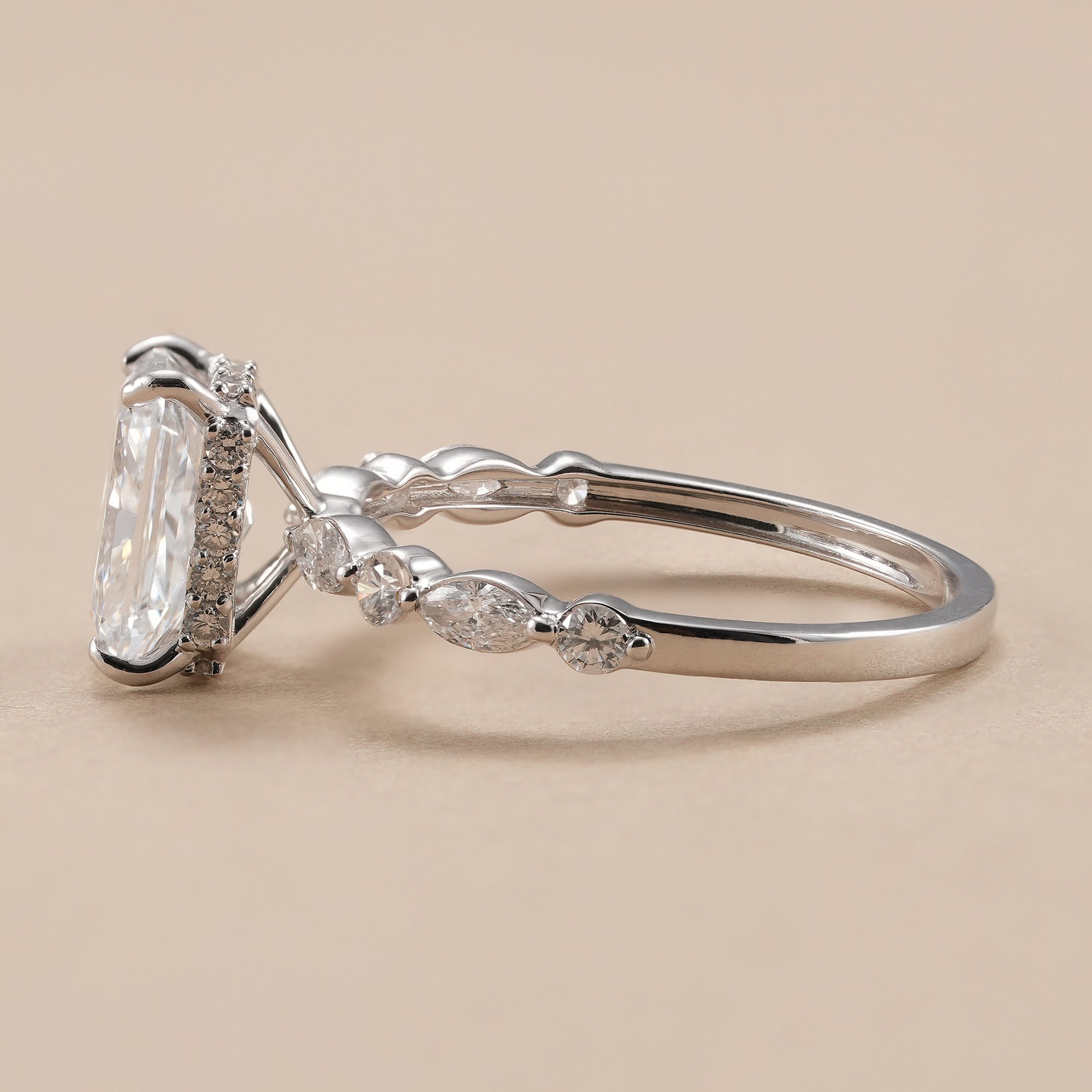 Radiant diamond engagement ring with marquise and round diamond band.