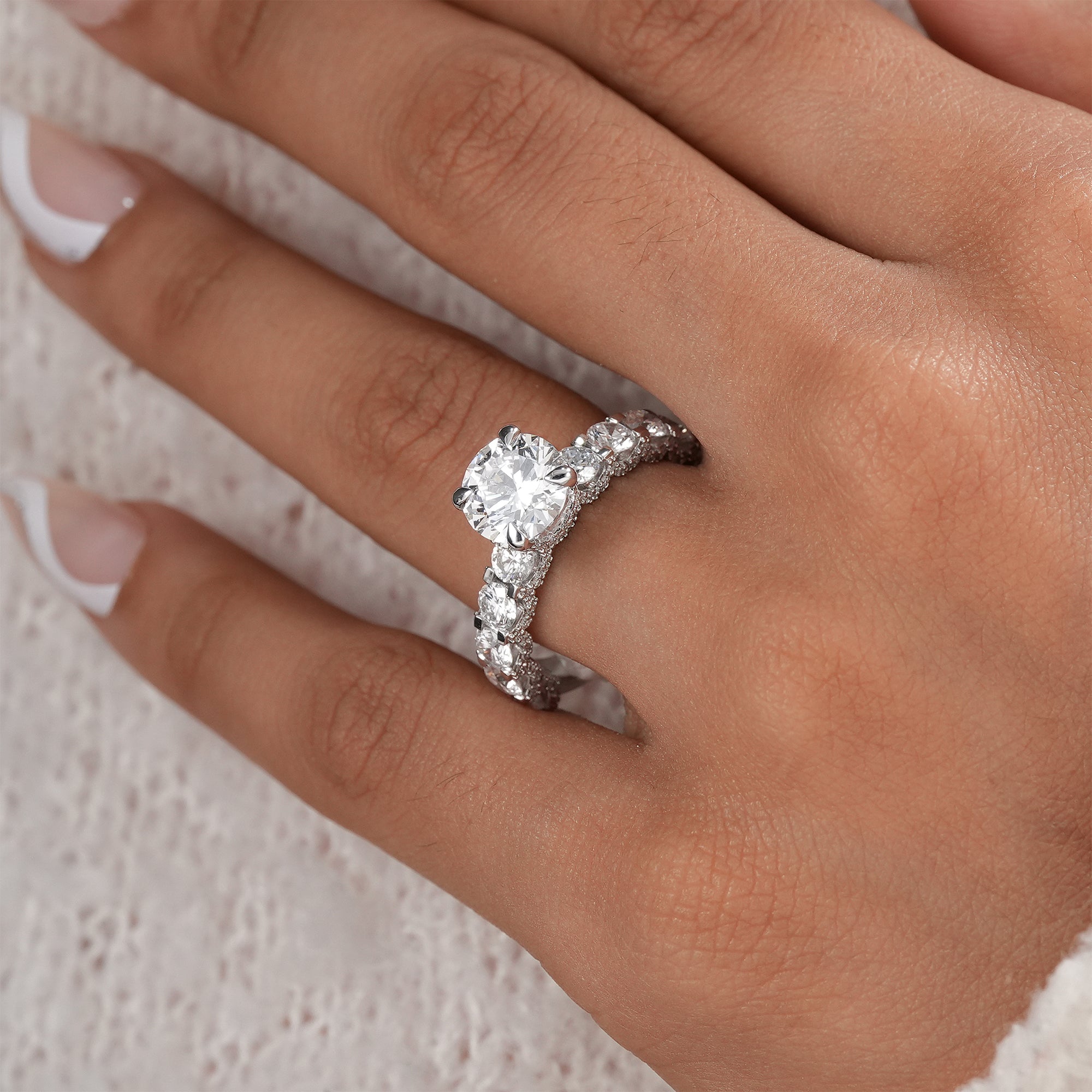 Handcrafted hidden halo engagement ring with round center diamond.
