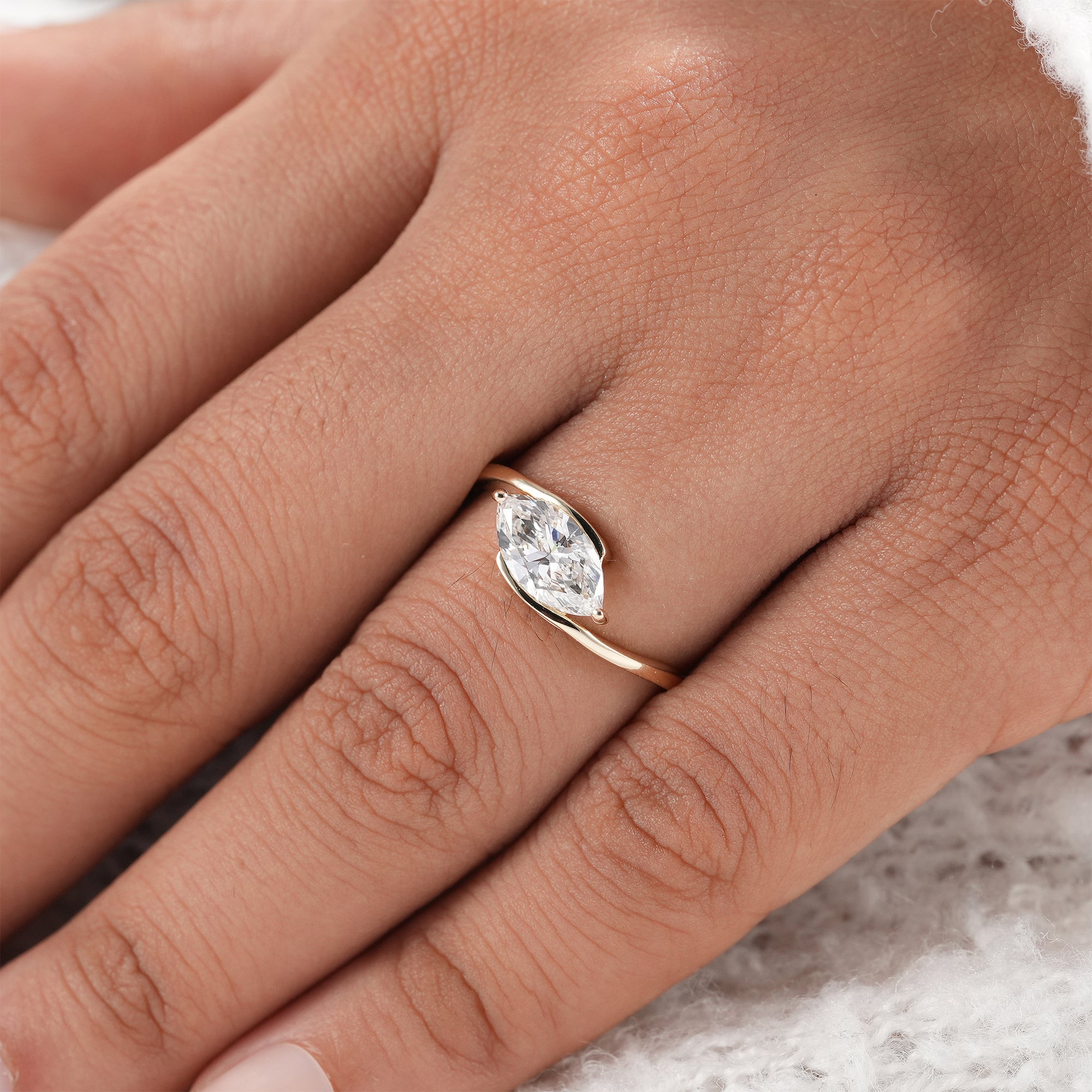 Contemporary bypass ring with marquise lab diamond.