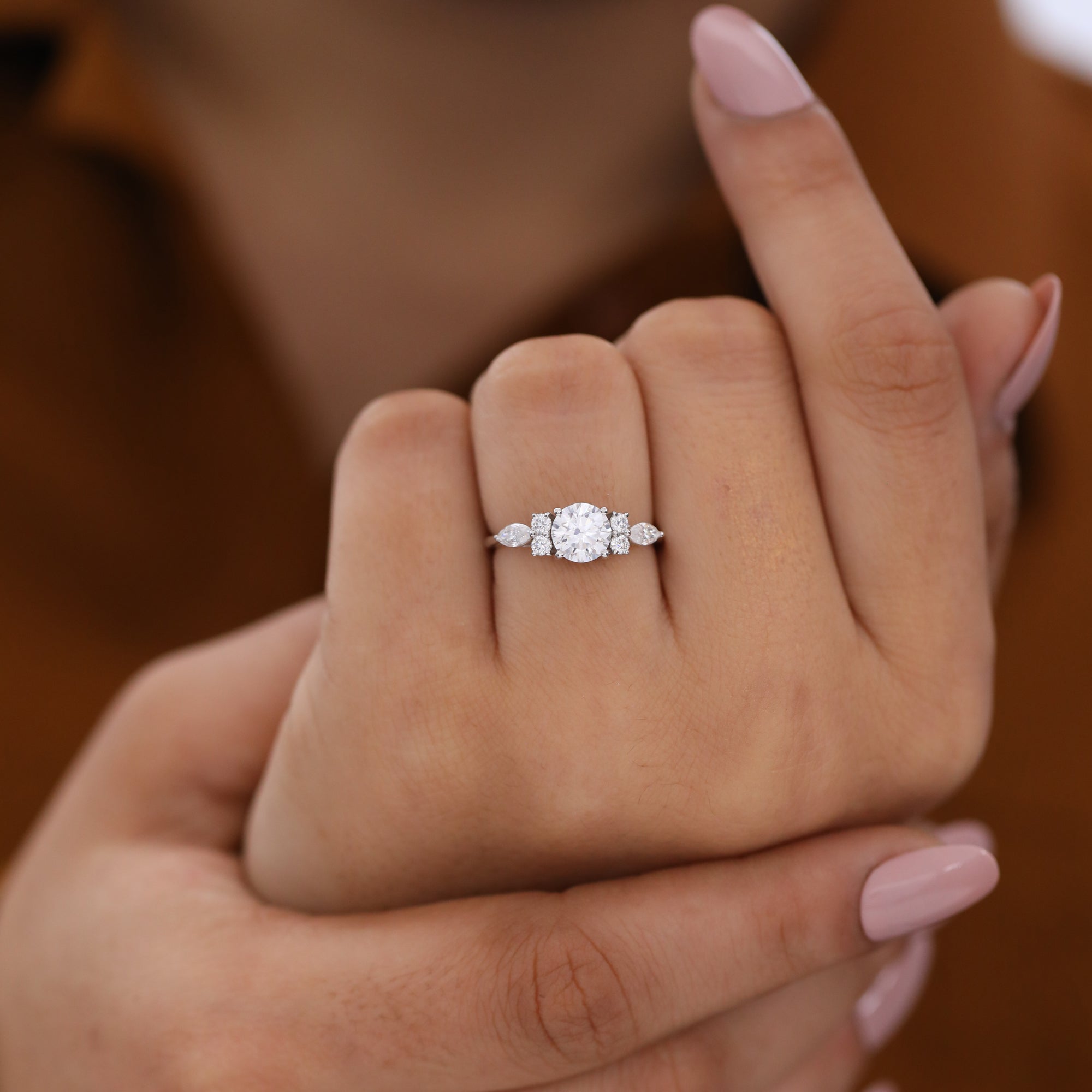 Modern round lab diamond ring with marquise and round accent stones for engagement.