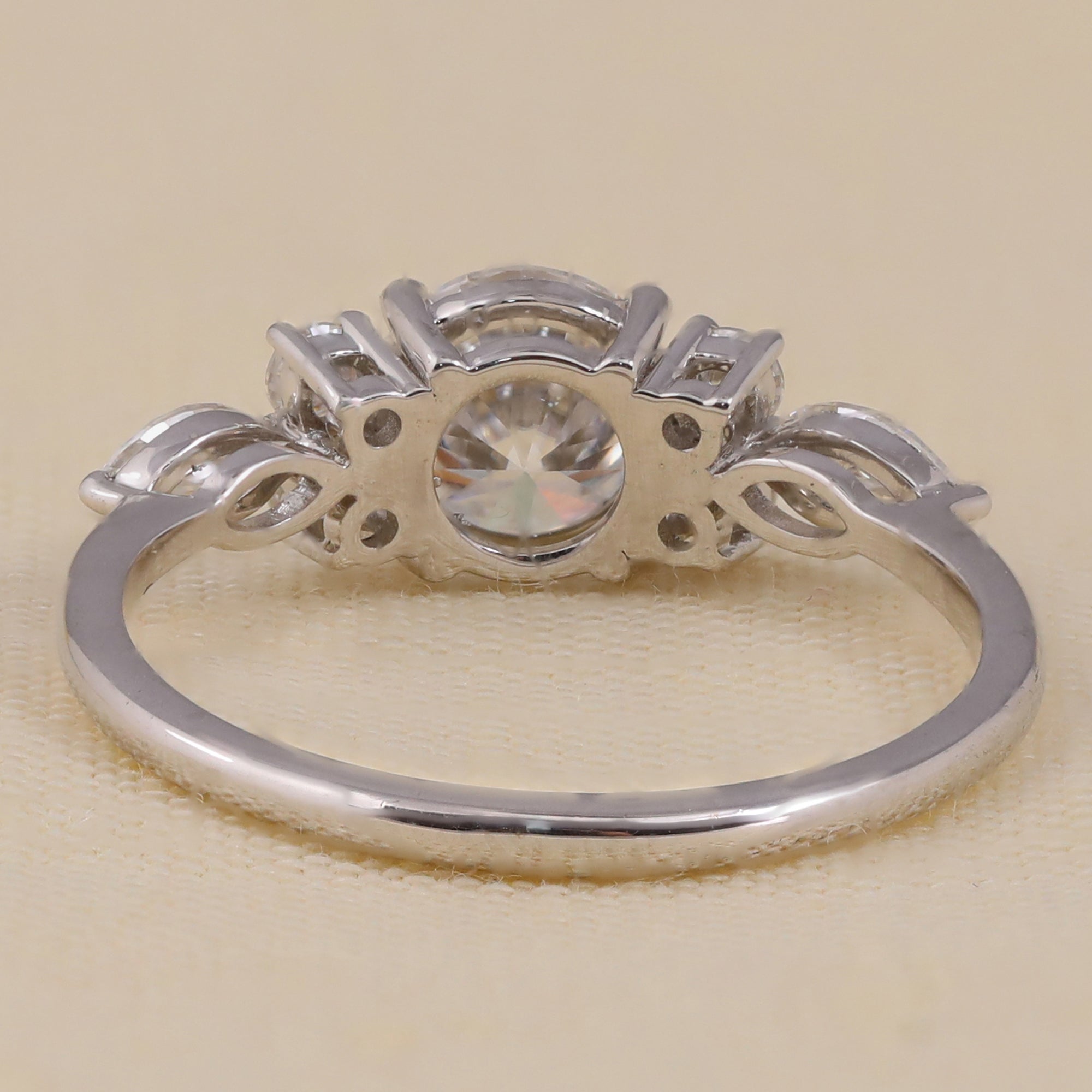 Round cut lab diamond engagement ring with cluster side stones for bridal jewelry.