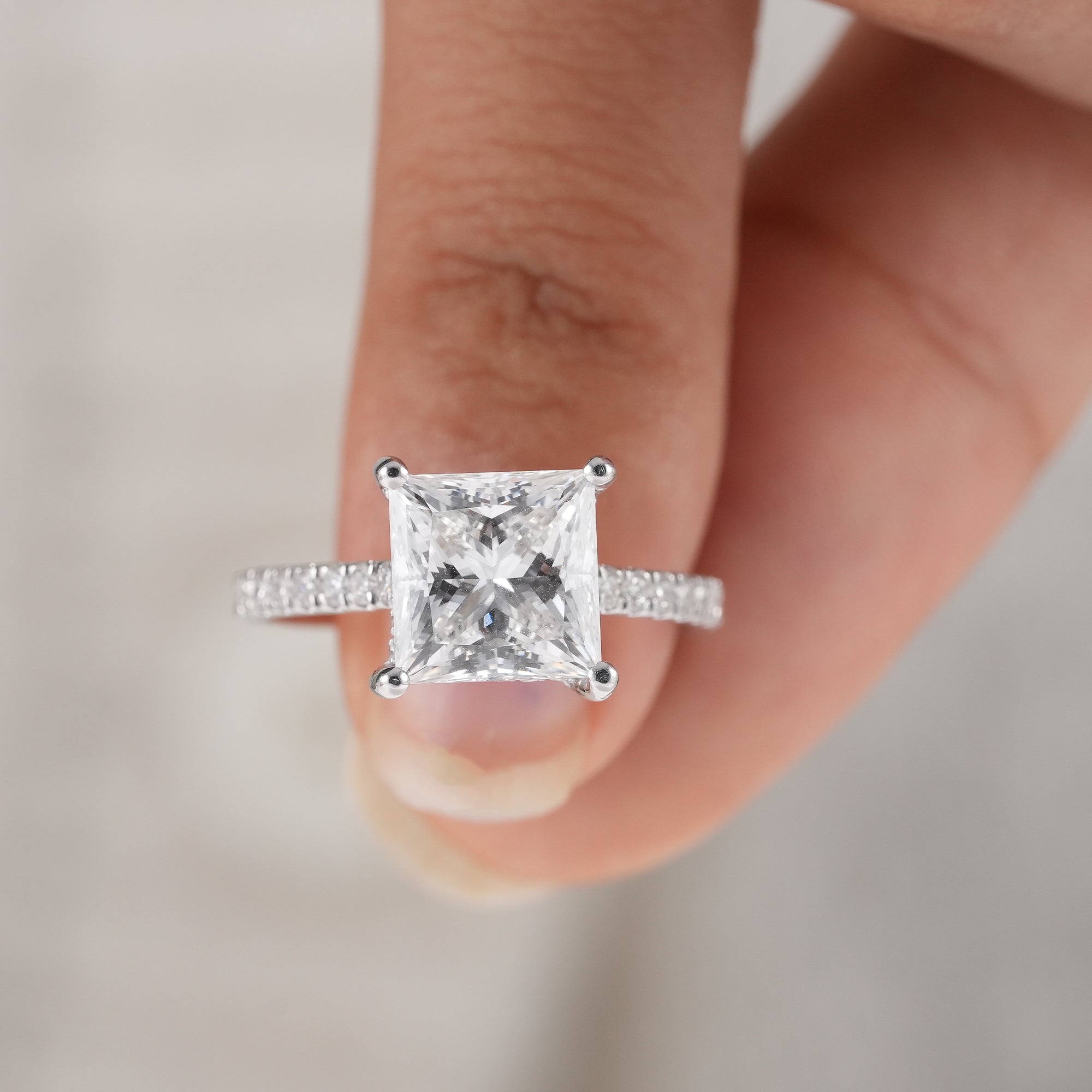 Princess cut engagement ring with pavé diamond shank.