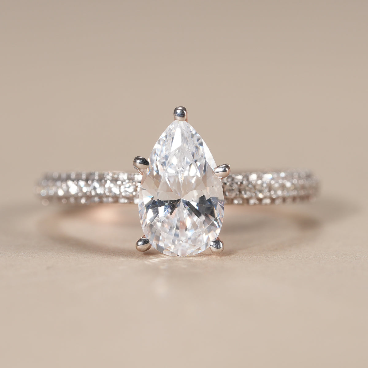 Pear lab grown diamond engagement ring featuring a brilliant 1 CT center stone and pavé band.