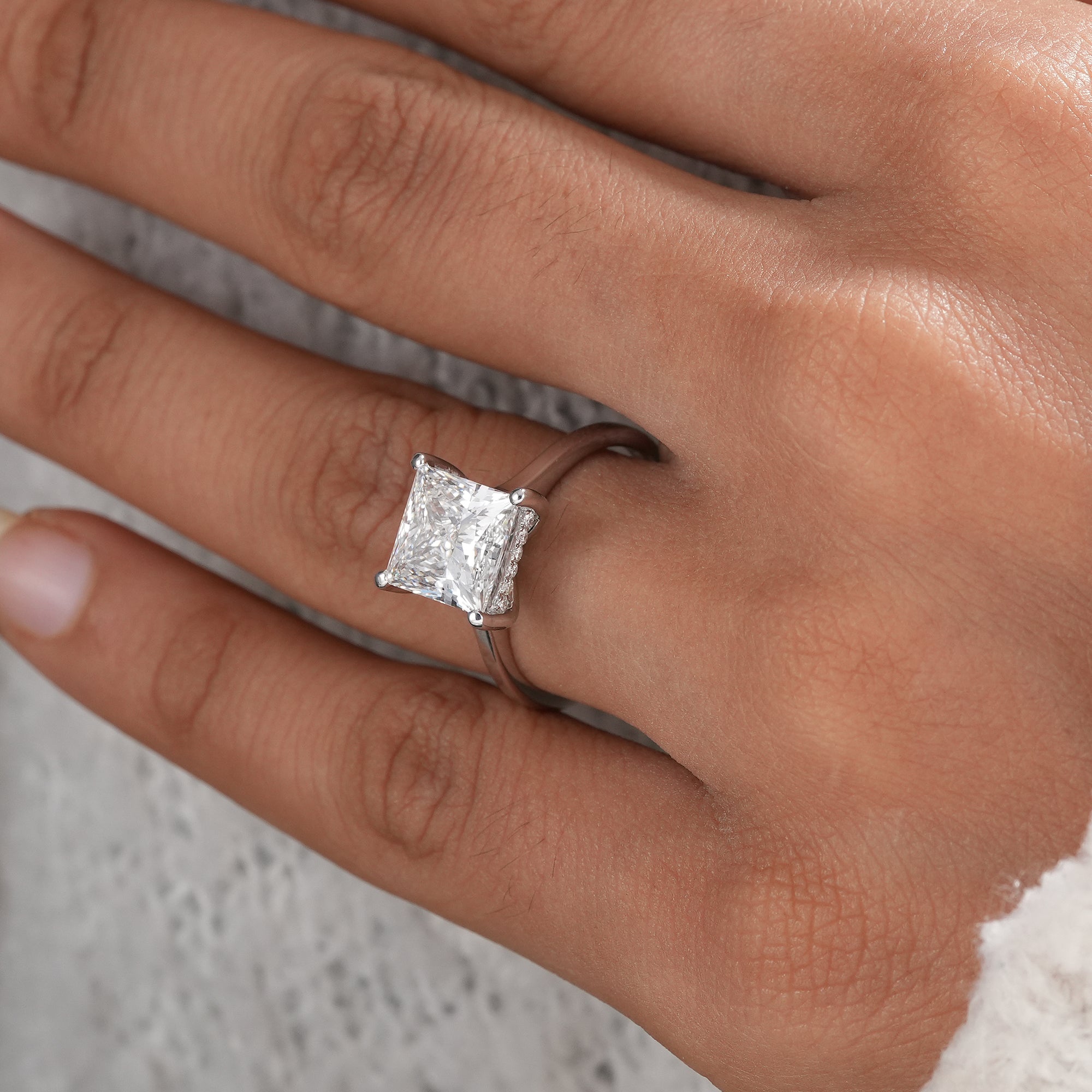 Princess cut diamond engagement ring with four-prong setting.