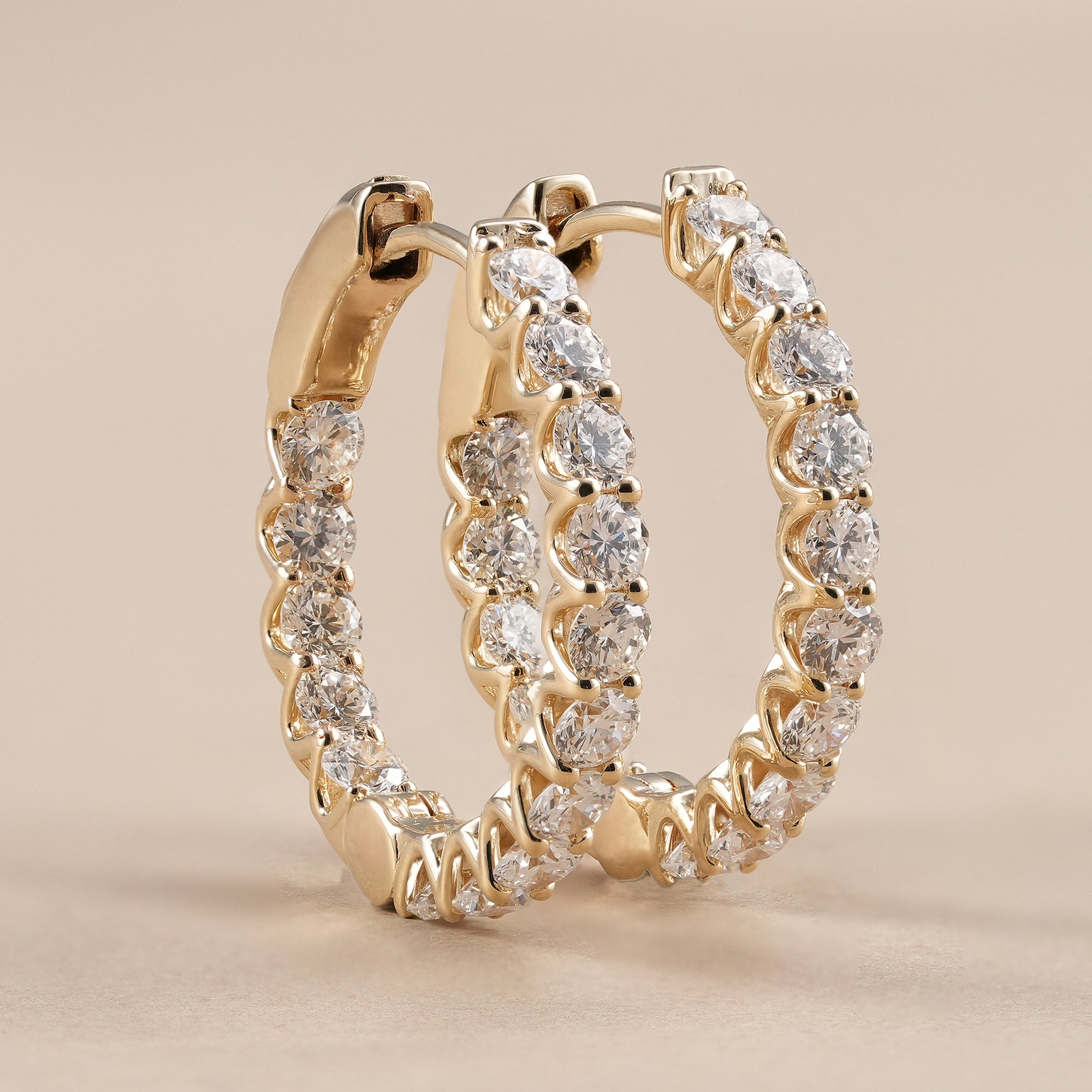 Round lab grown diamond huggie hoop earrings featuring brilliant double prong set diamonds