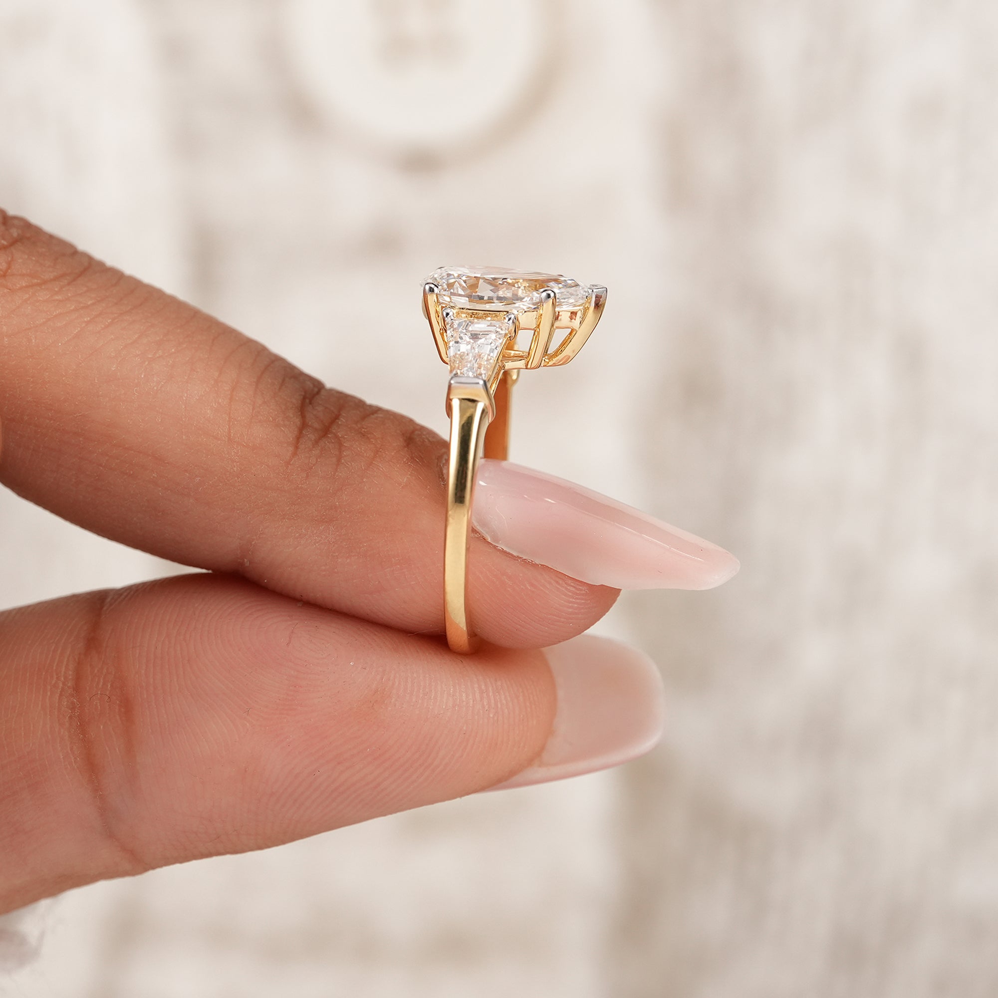 Pear anniversary ring featuring tapered baguette side diamonds