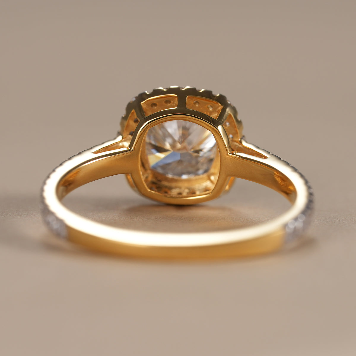 Cushion cut lab grown diamond ring with handcrafted halo setting and polished gold band.