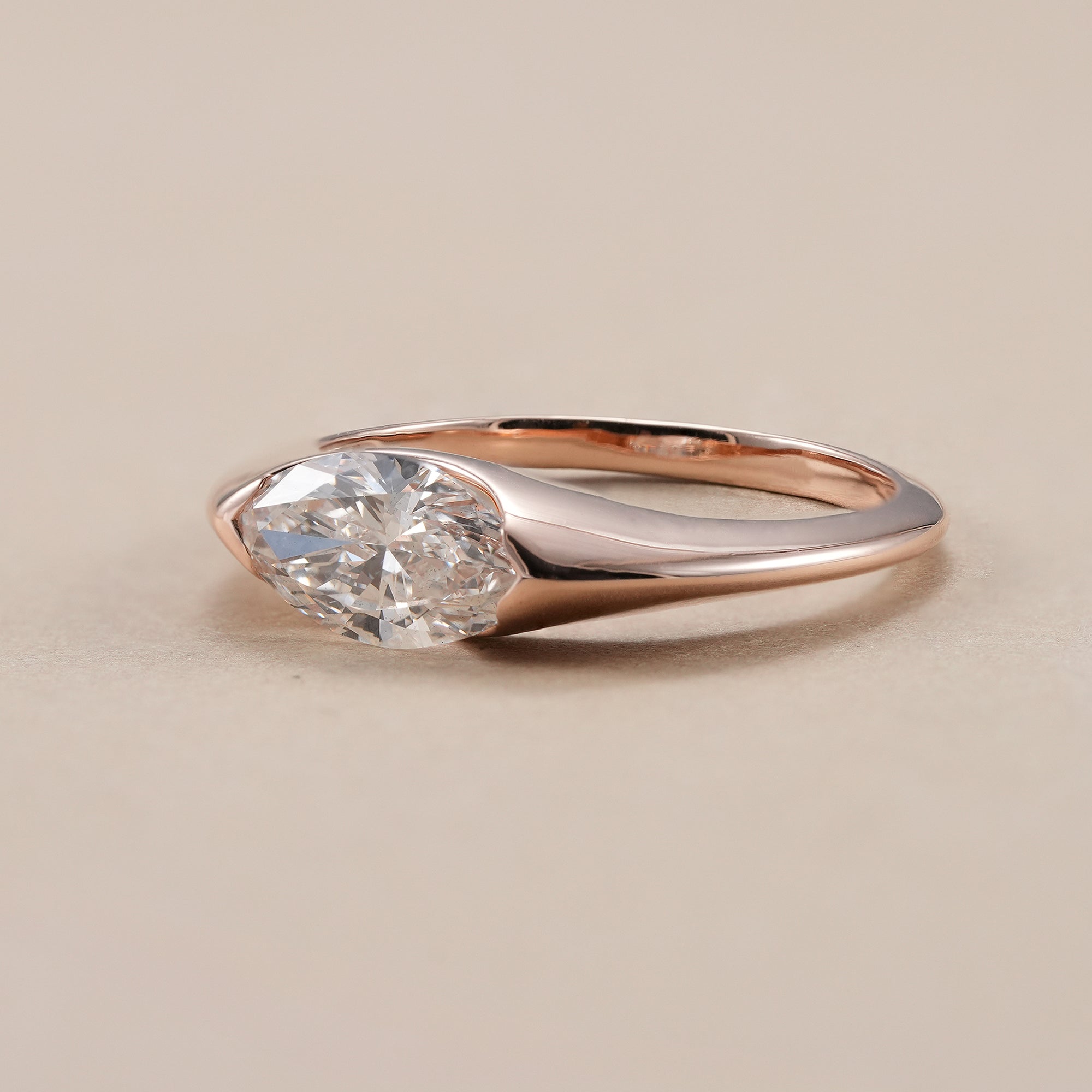 Modern marquise solitaire engagement ring in rose gold.