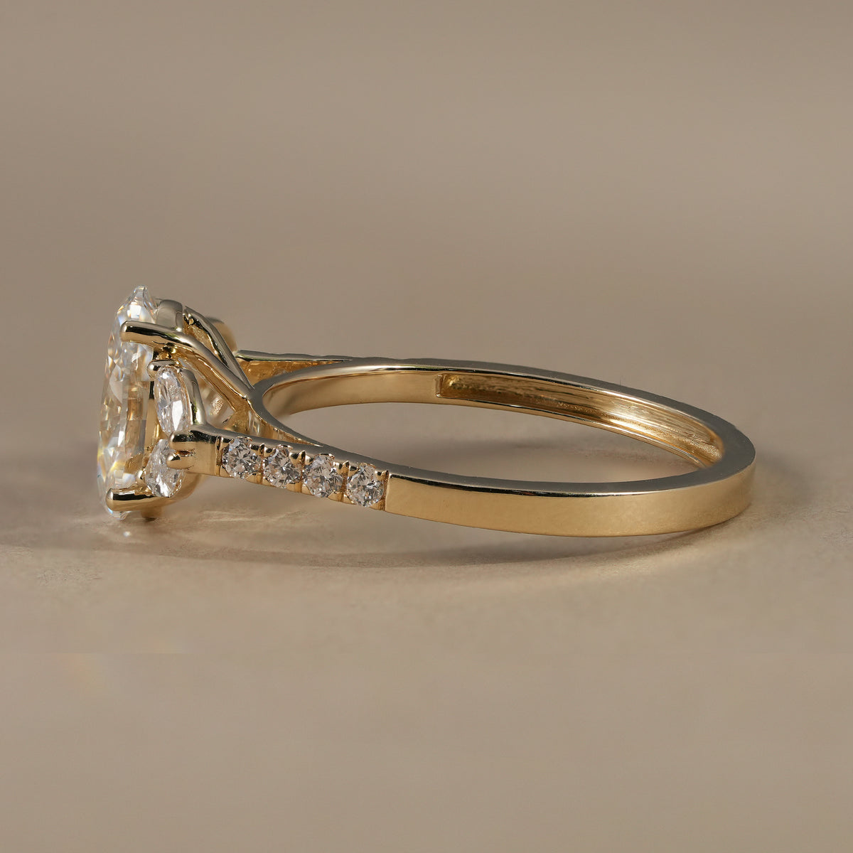Elegant oval lab diamond ring with round accent diamonds and floral cluster setting.