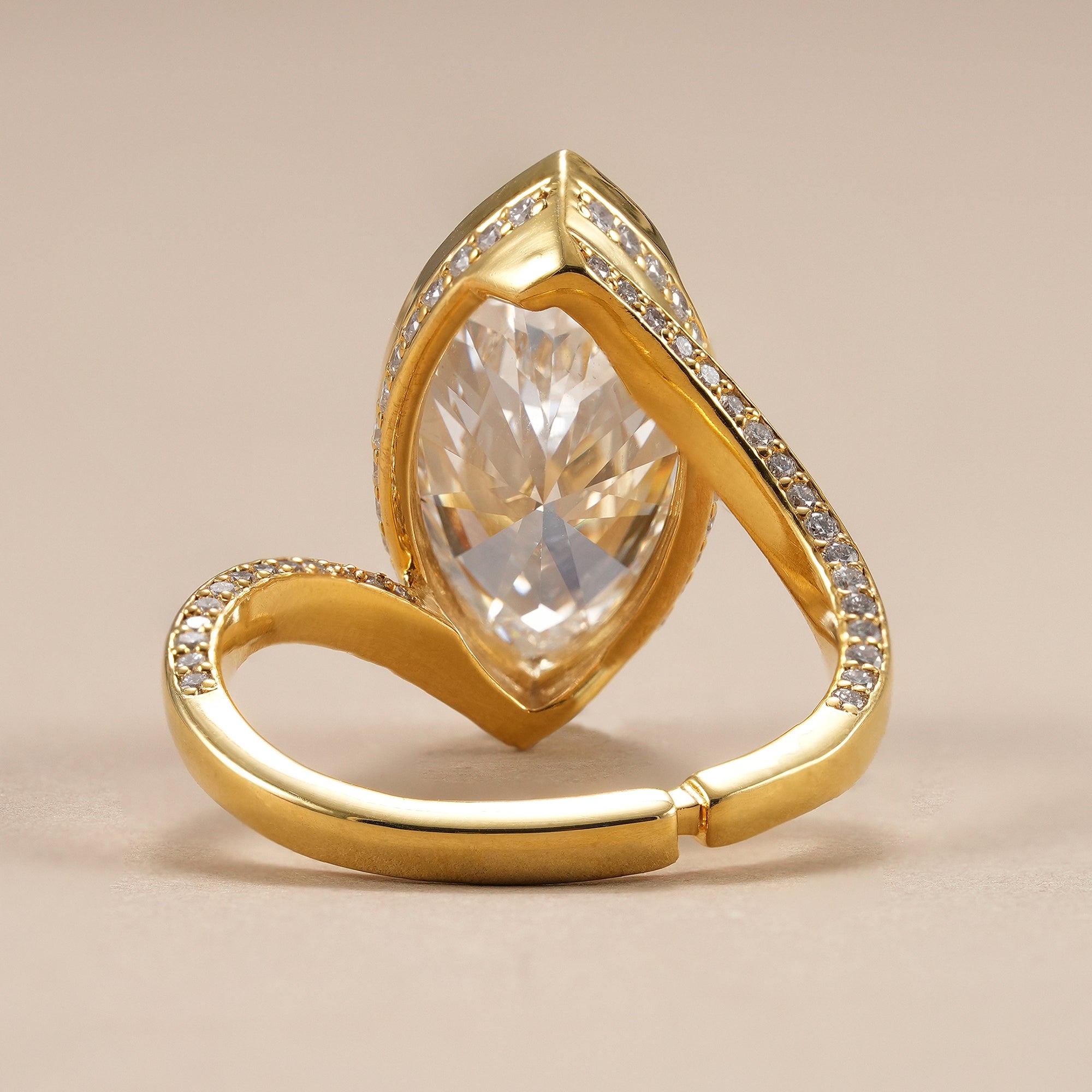 Elegant bypass diamond ring featuring a bezel set marquise center stone.