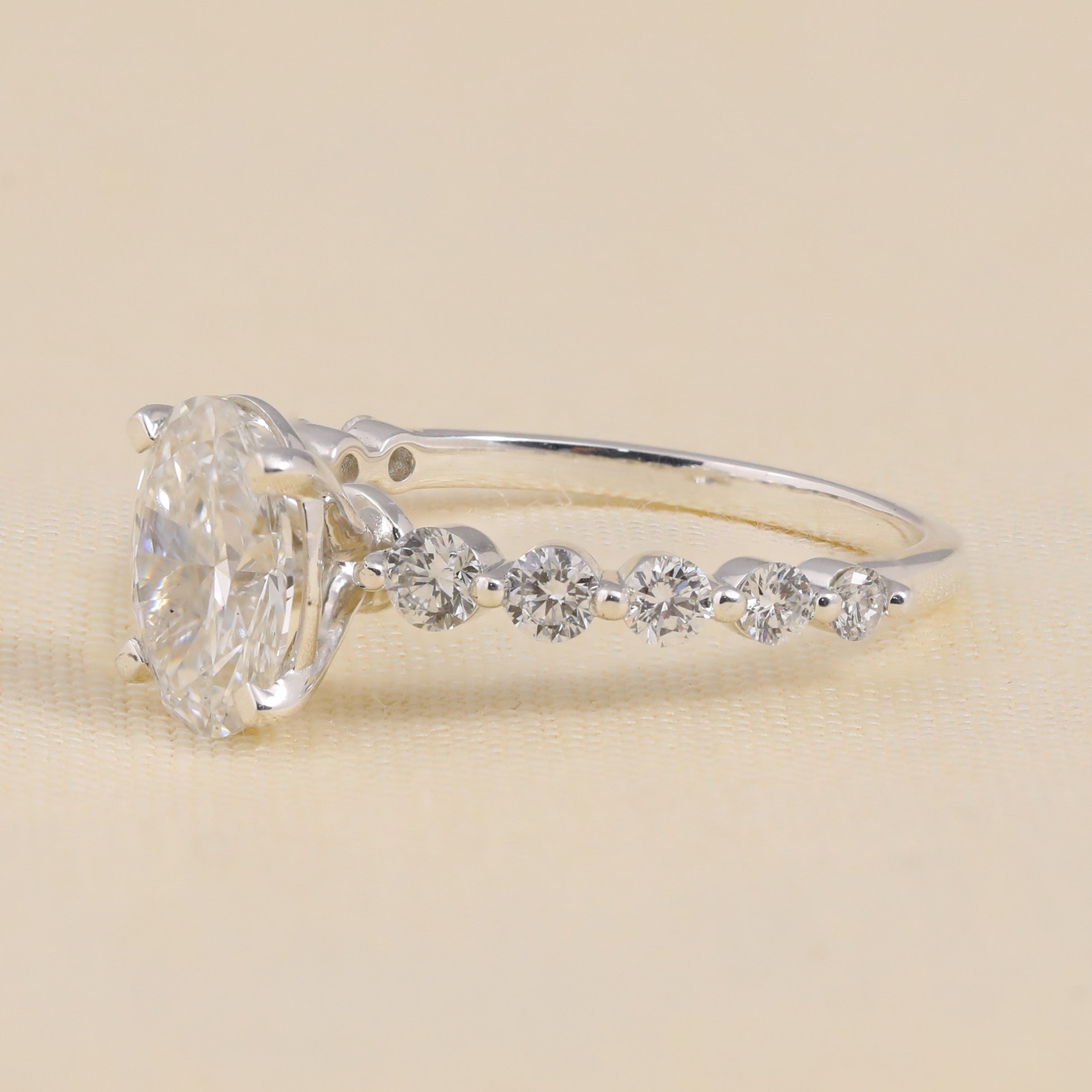 Bridal engagement ring with oval lab-grown diamond and graduated side stones