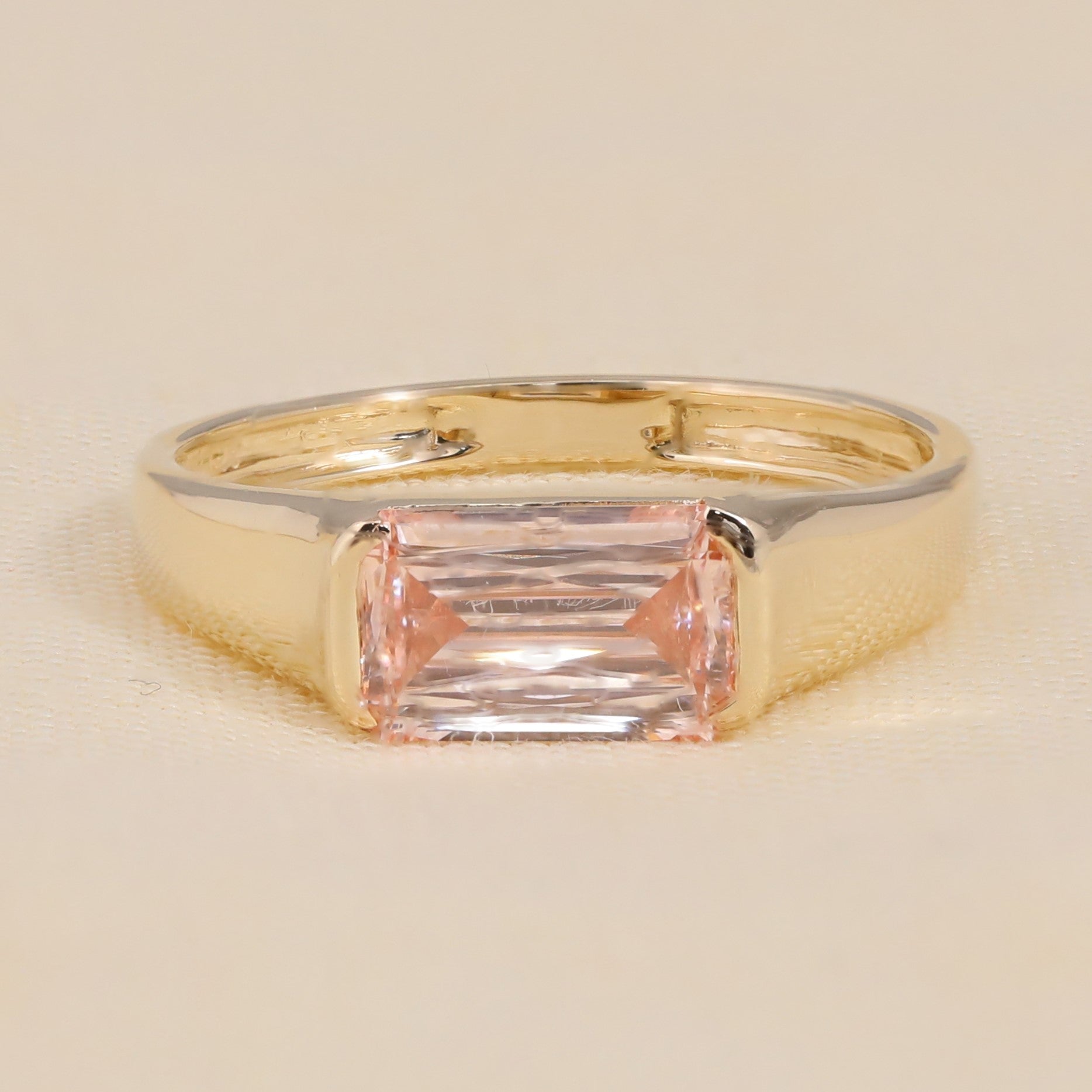 Emerald cut pink lab grown diamond ring in gold bezel setting for women.