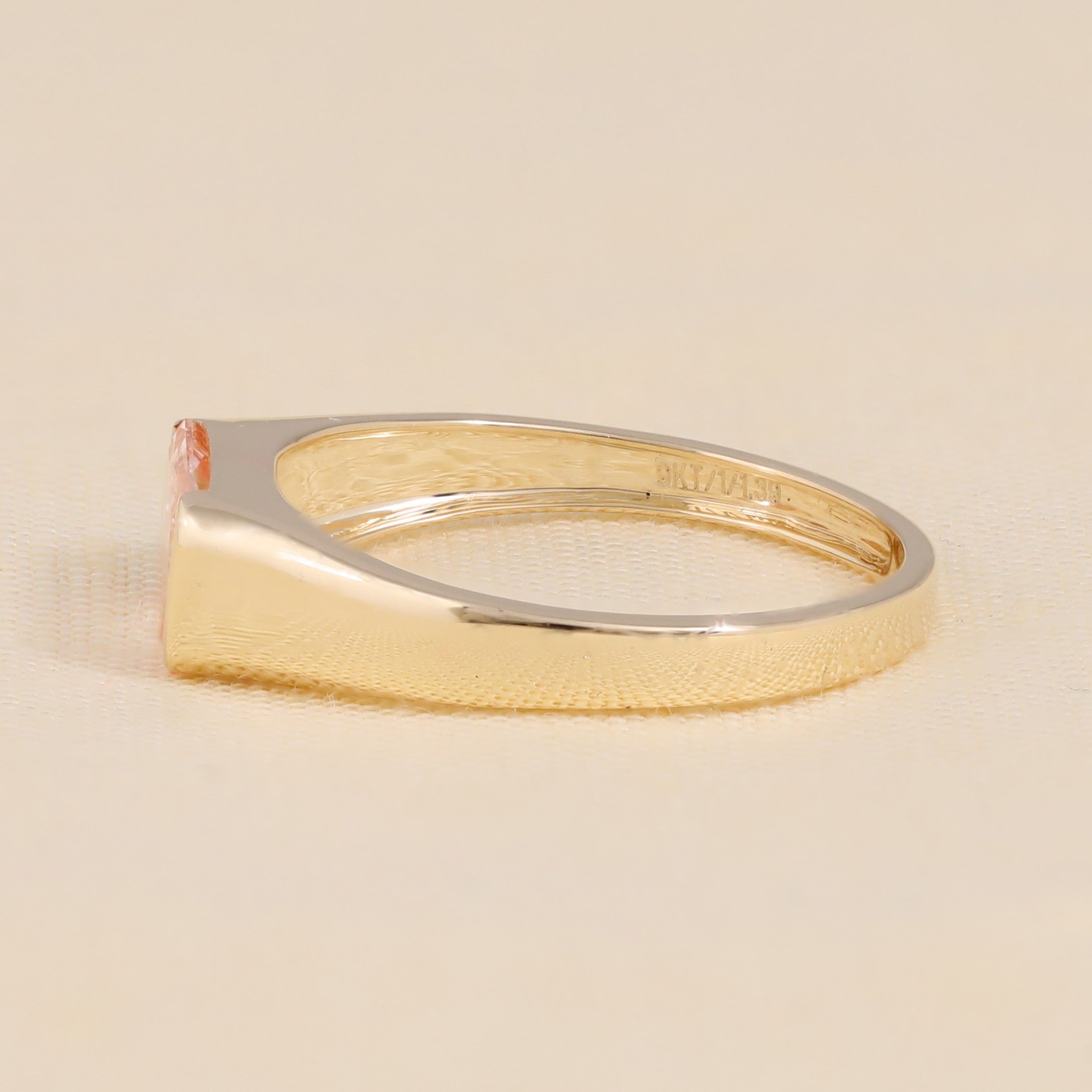 Modern gold engagement ring with pink emerald cut lab diamond.