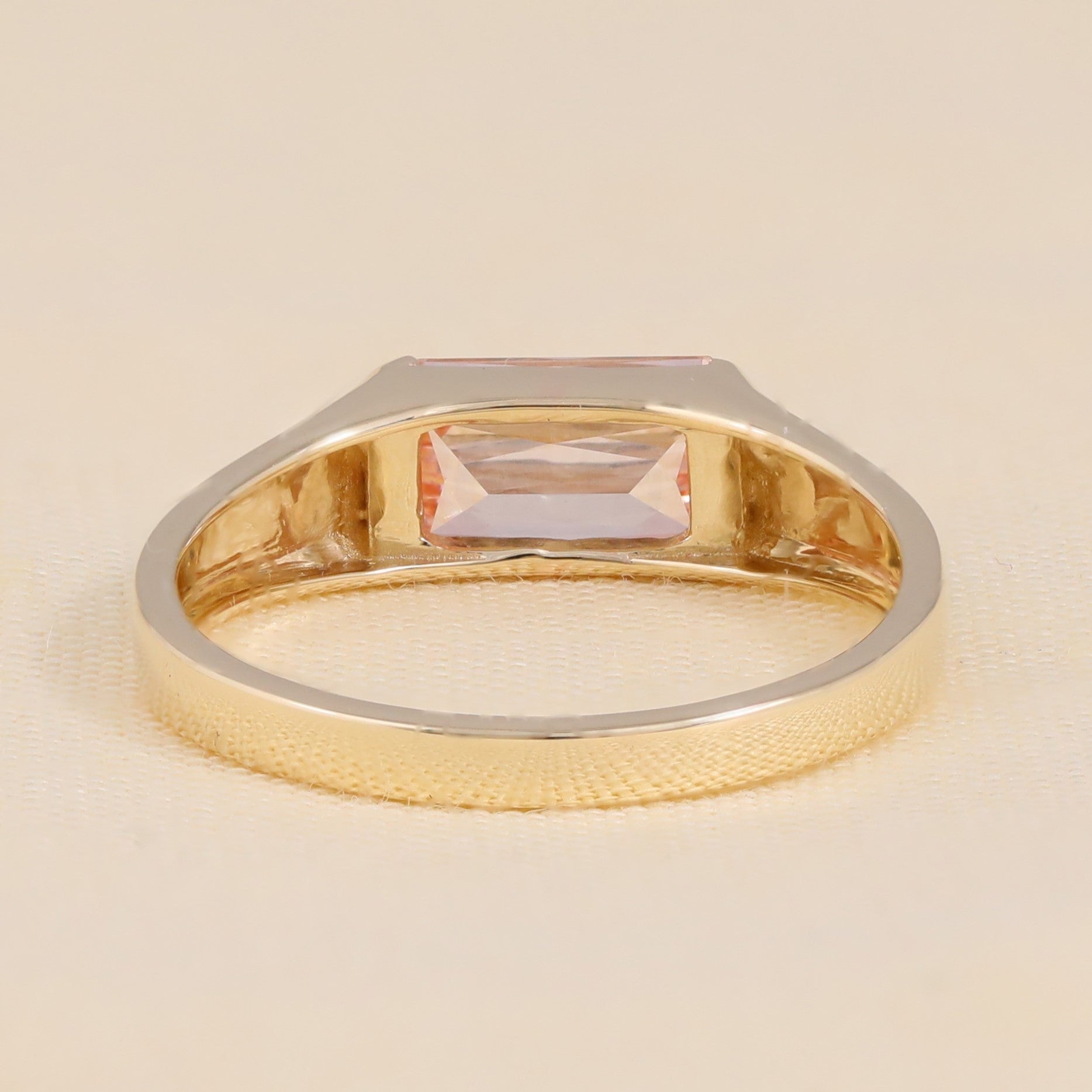 Modern gold engagement ring with pink emerald cut lab diamond.