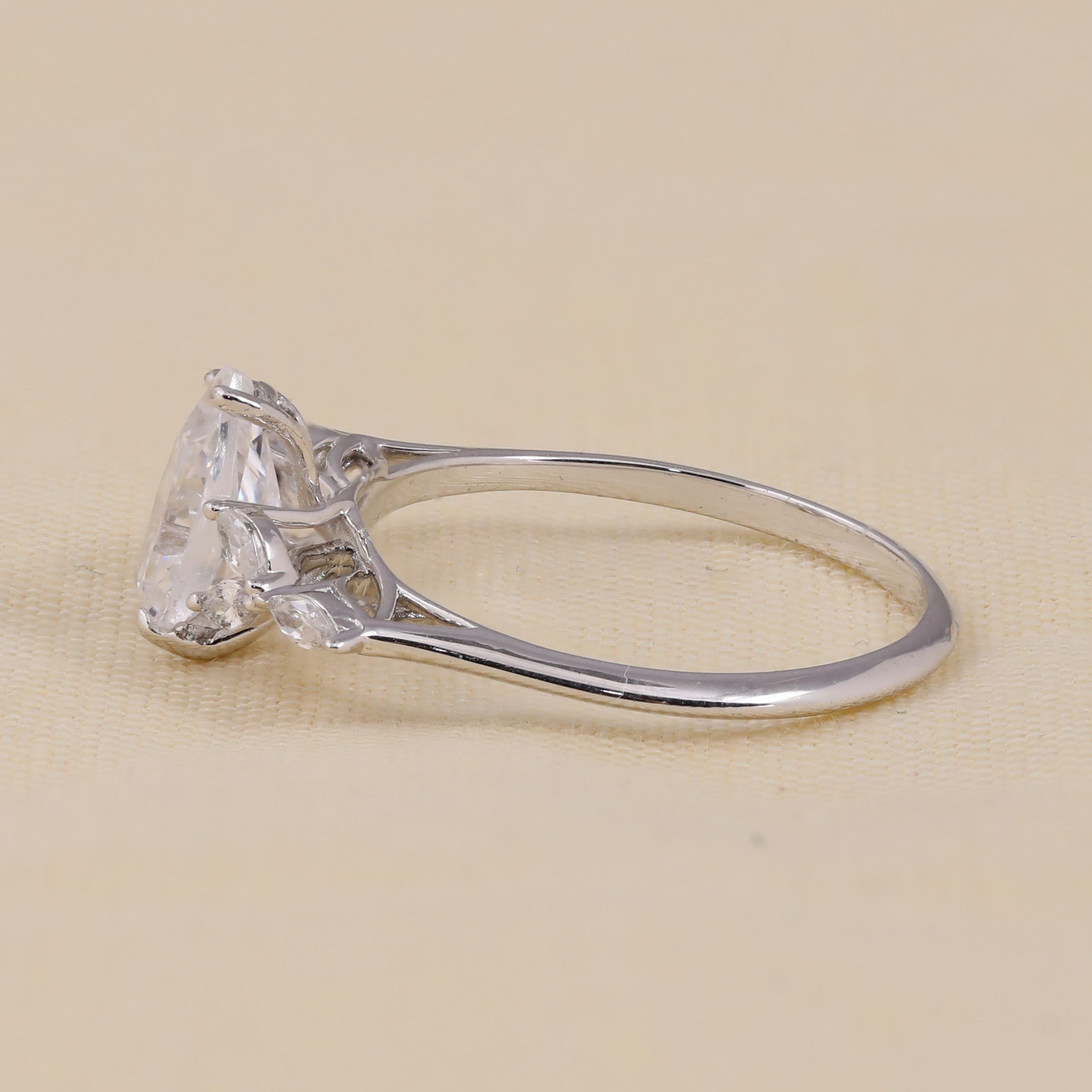 Pear cut lab created diamond engagement ring with marquise cluster design.