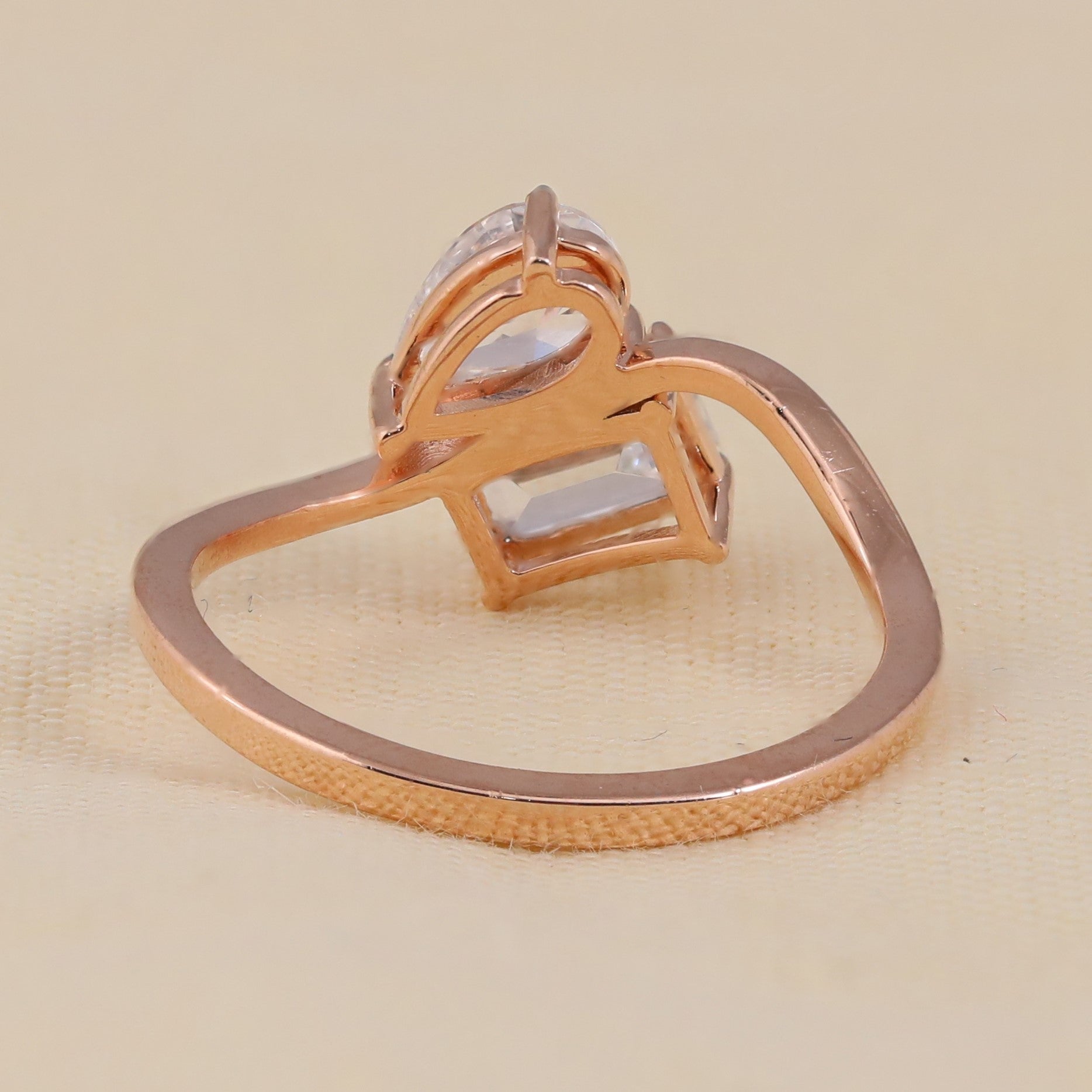 Pear shaped and emerald cut diamond bypass engagement ring