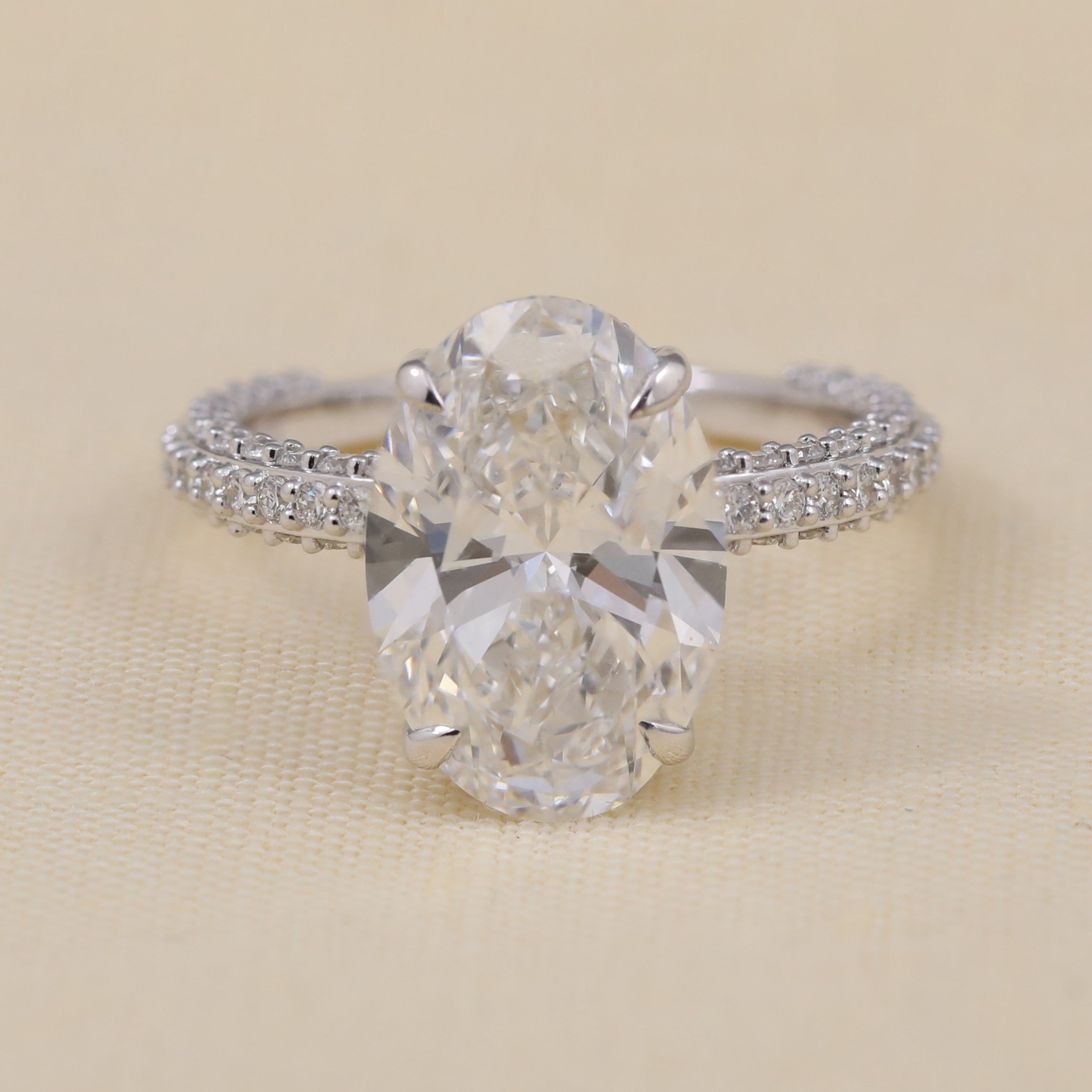 Oval lab grown diamond engagement ring featuring a sparkling triple row pavé band