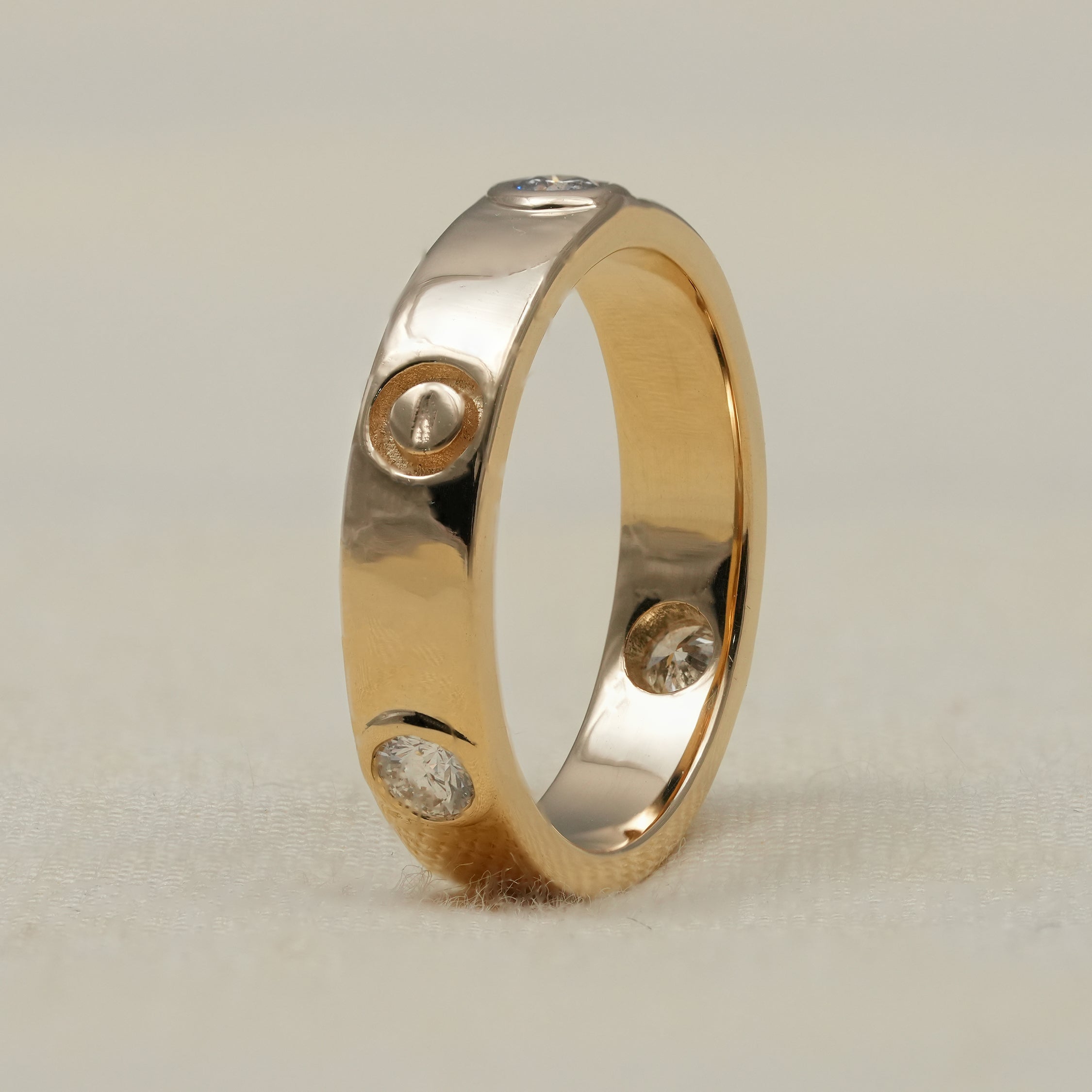 Polished gold lab grown diamond wedding band with bezel set stones