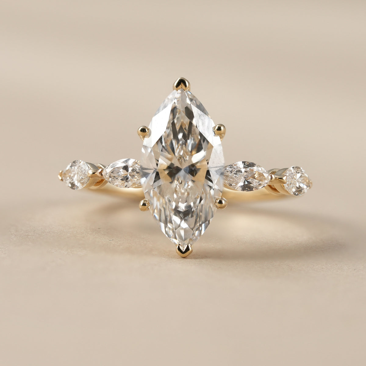 2 CT marquise lab grown diamond engagement ring with marquise and round accent diamonds in solid gold.
