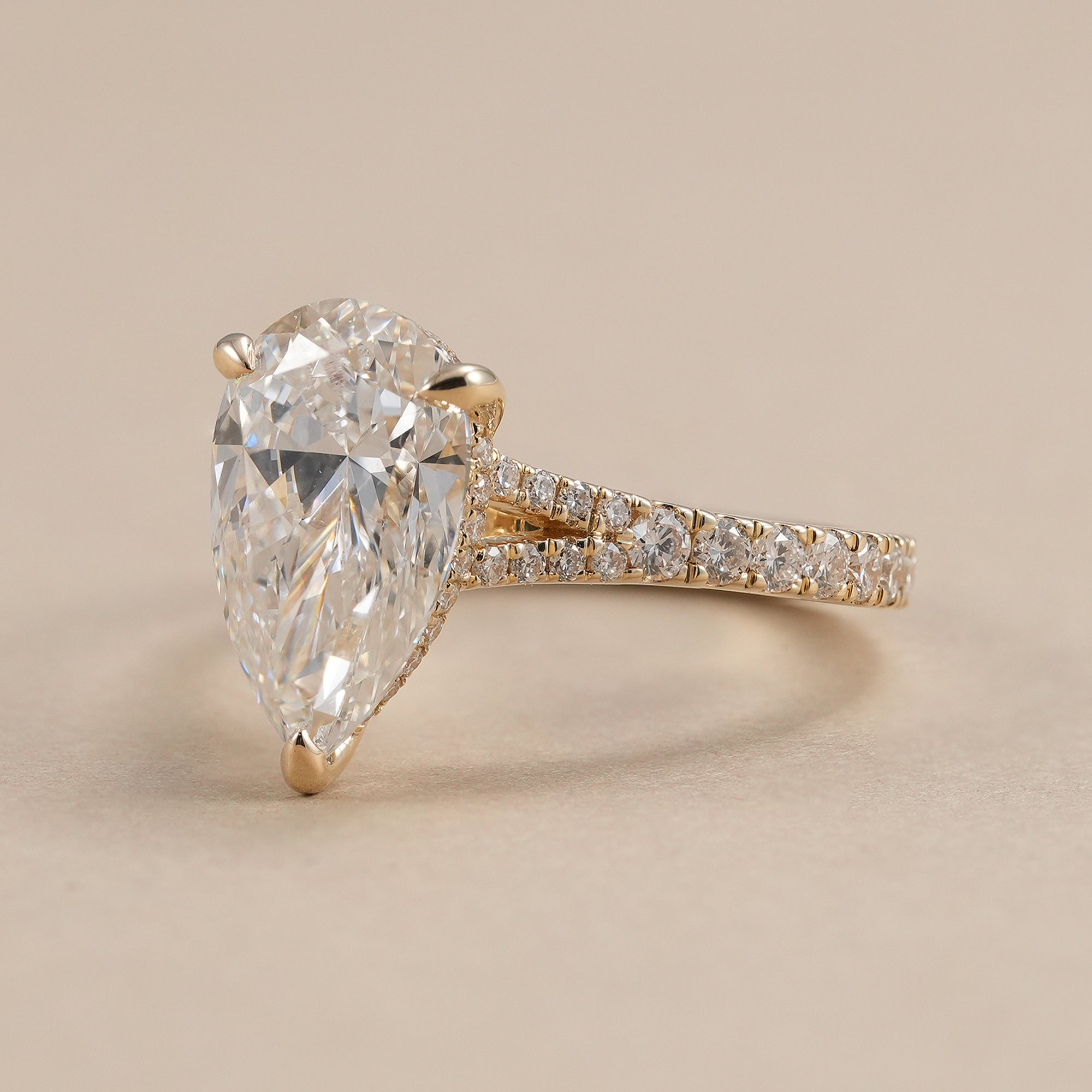 Pear shaped lab grown diamond engagement ring with pavé band