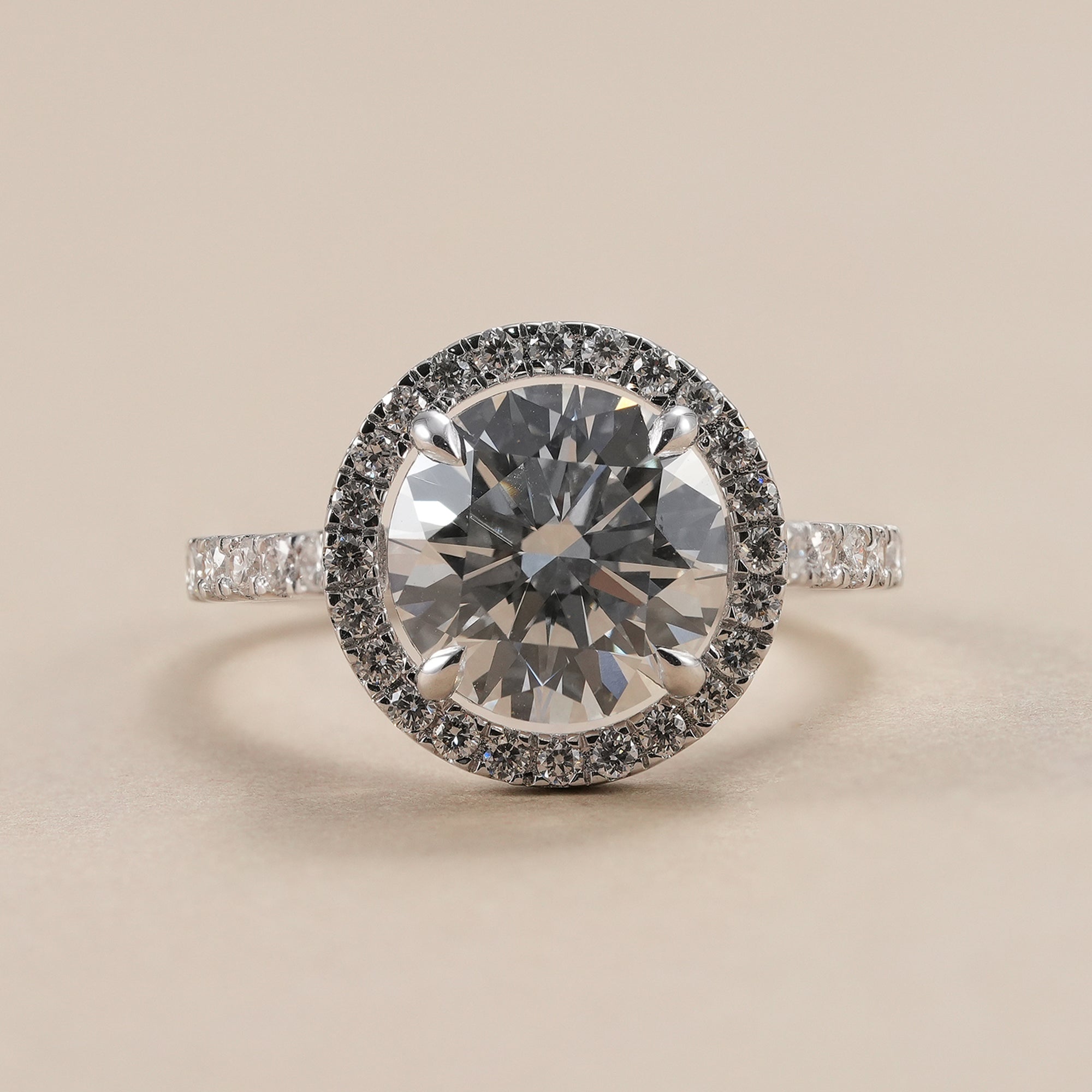 3 CT round lab grown diamond halo engagement ring with pavé band.