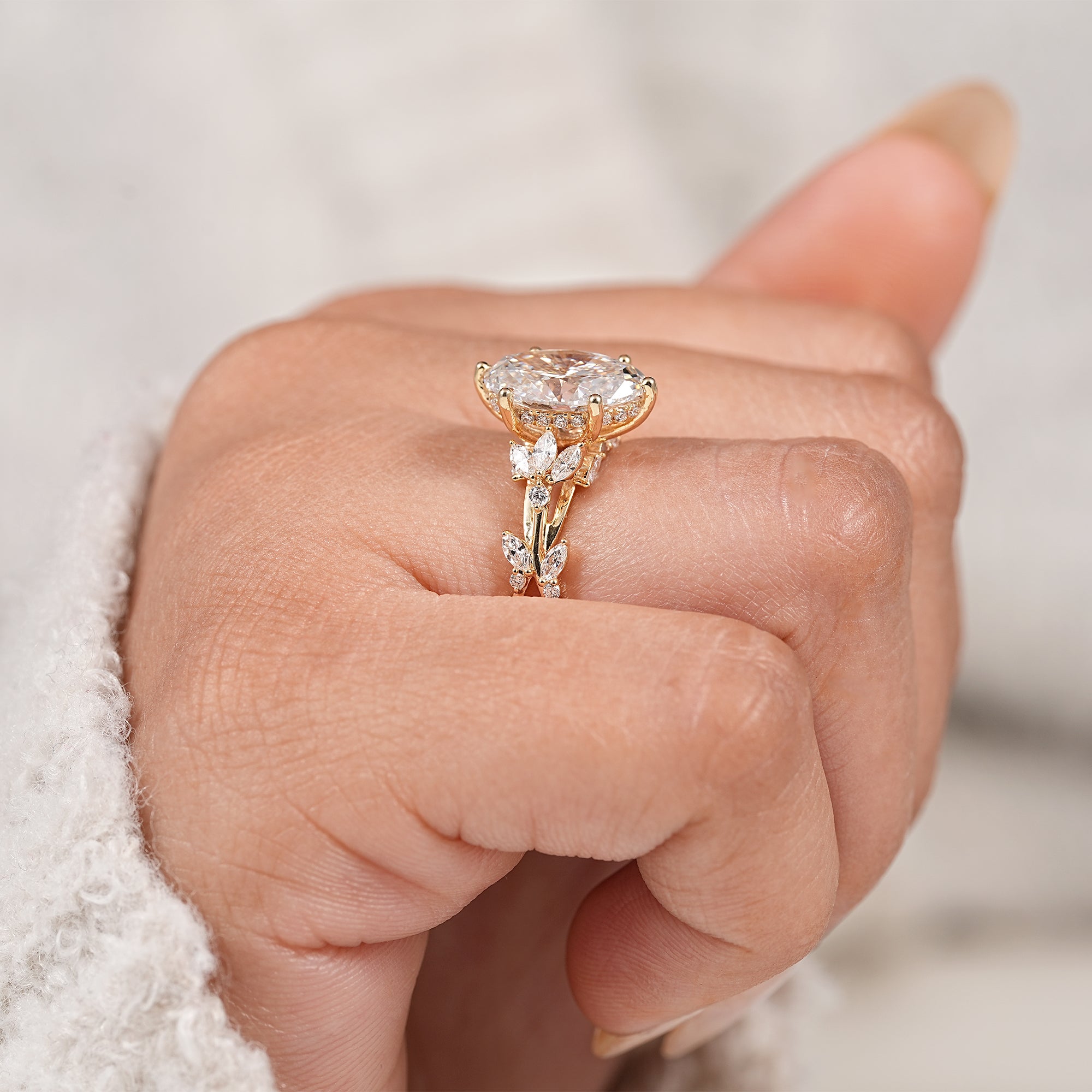 Oval solitaire engagement ring with marquise leaf diamonds in twisted yellow gold