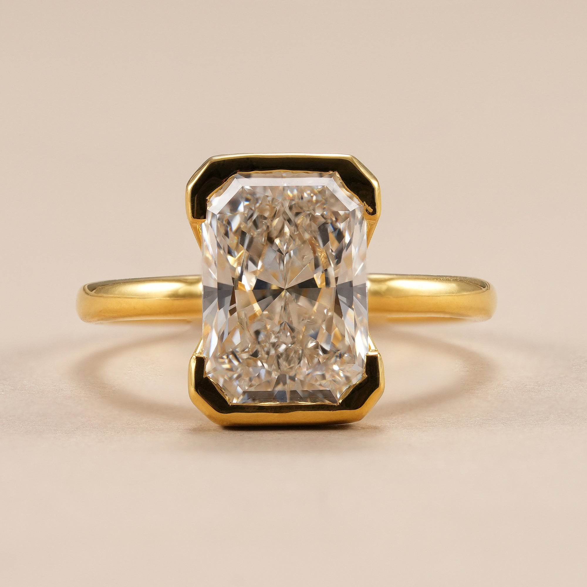 4 CT radiant lab grown diamond engagement ring in yellow gold half bezel setting.
