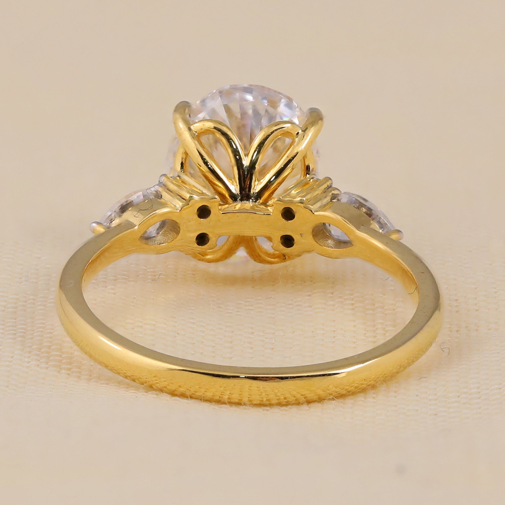 Gold three stone engagement ring with oval lab grown center diamond