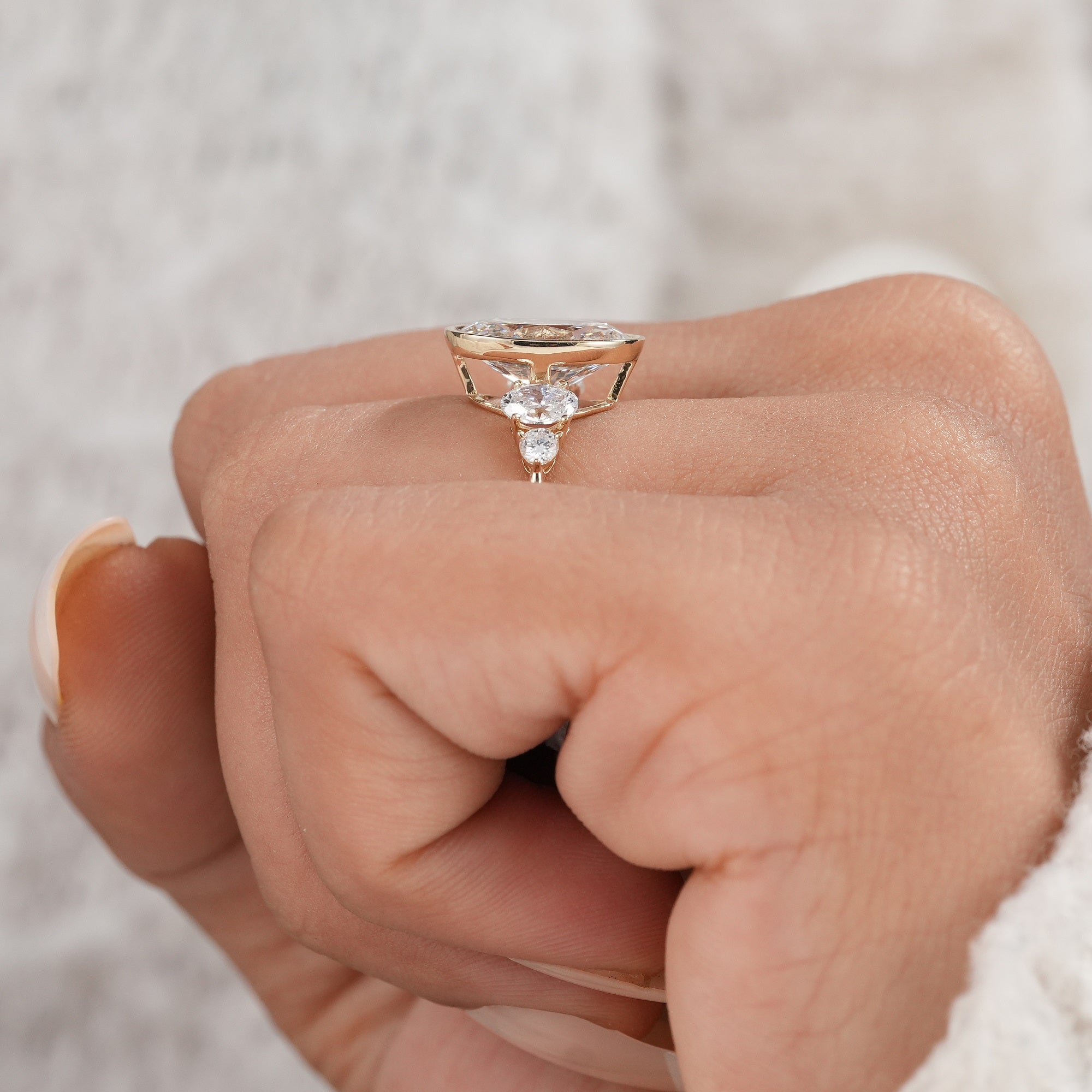 Oval cut bezel set diamond ring with brilliant side stones