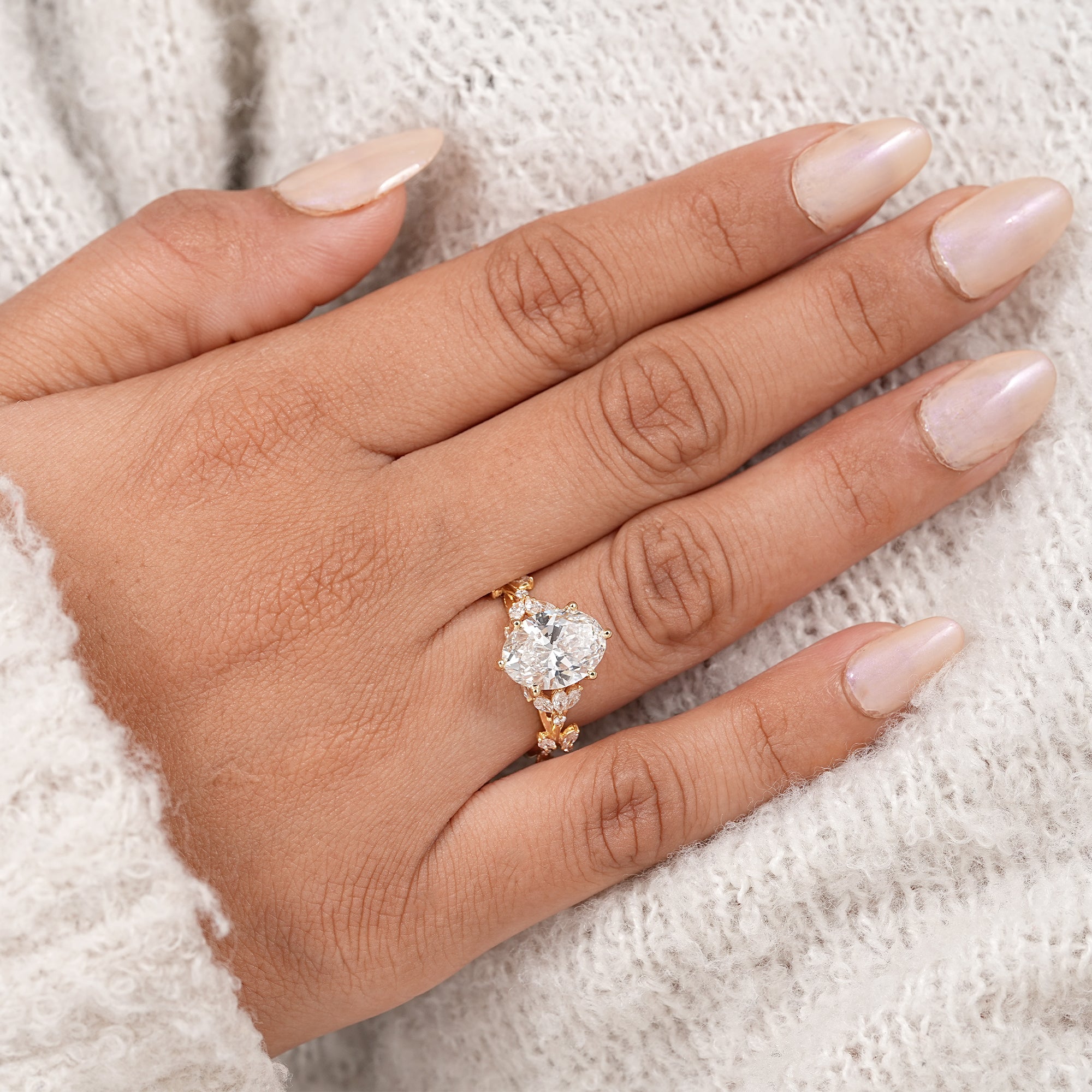 Romantic oval diamond engagement ring with marquise accents and yellow gold band