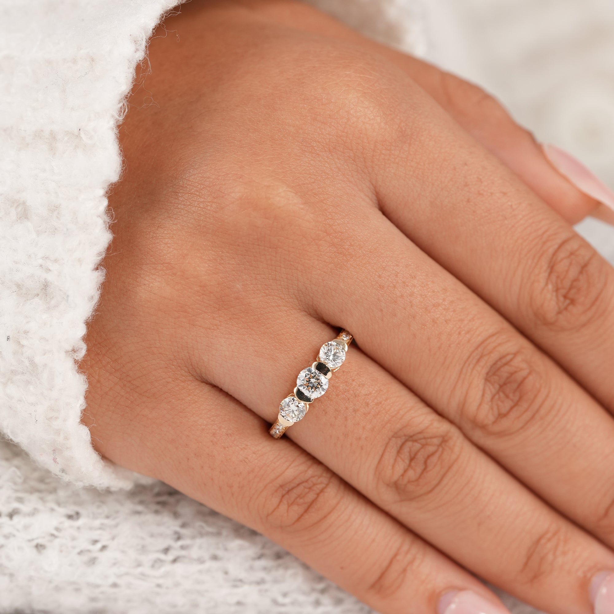 Classic three stone engagement ring with pavé band and round diamonds