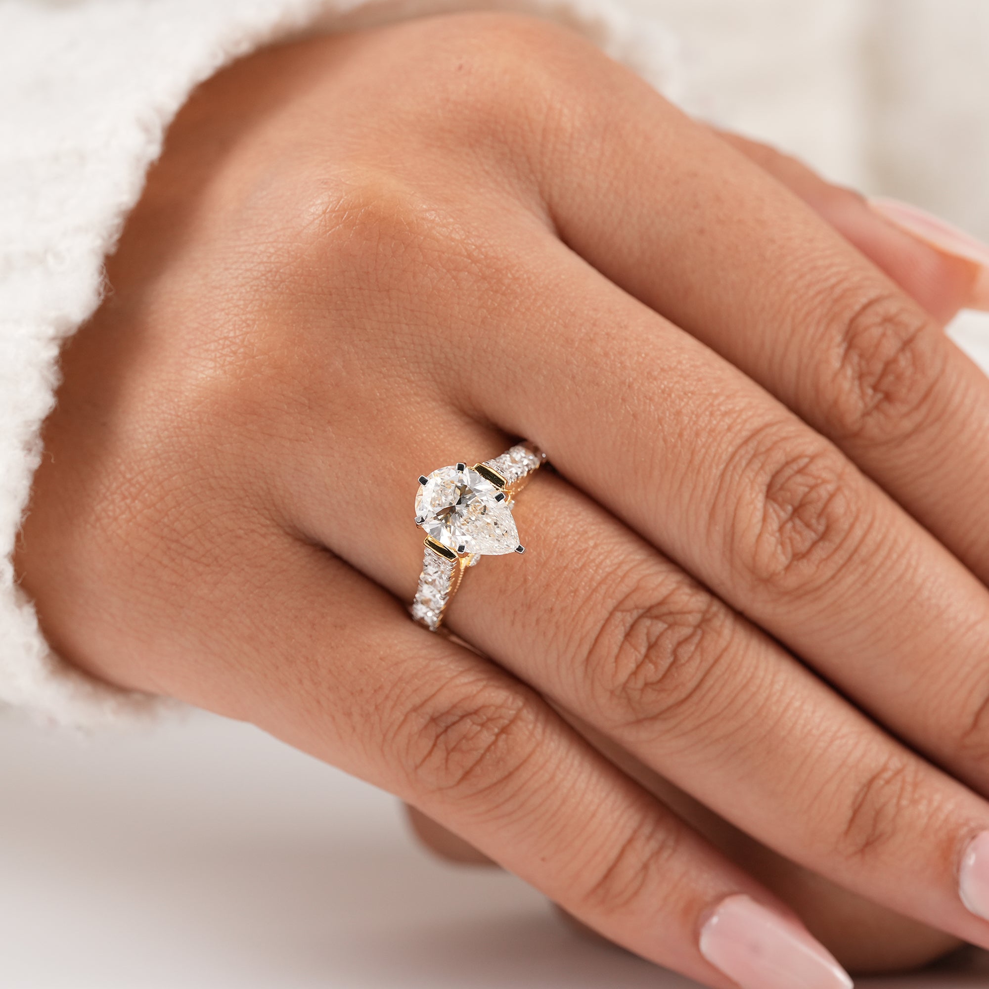 Pear engagement ring with sparkling pavé diamond band