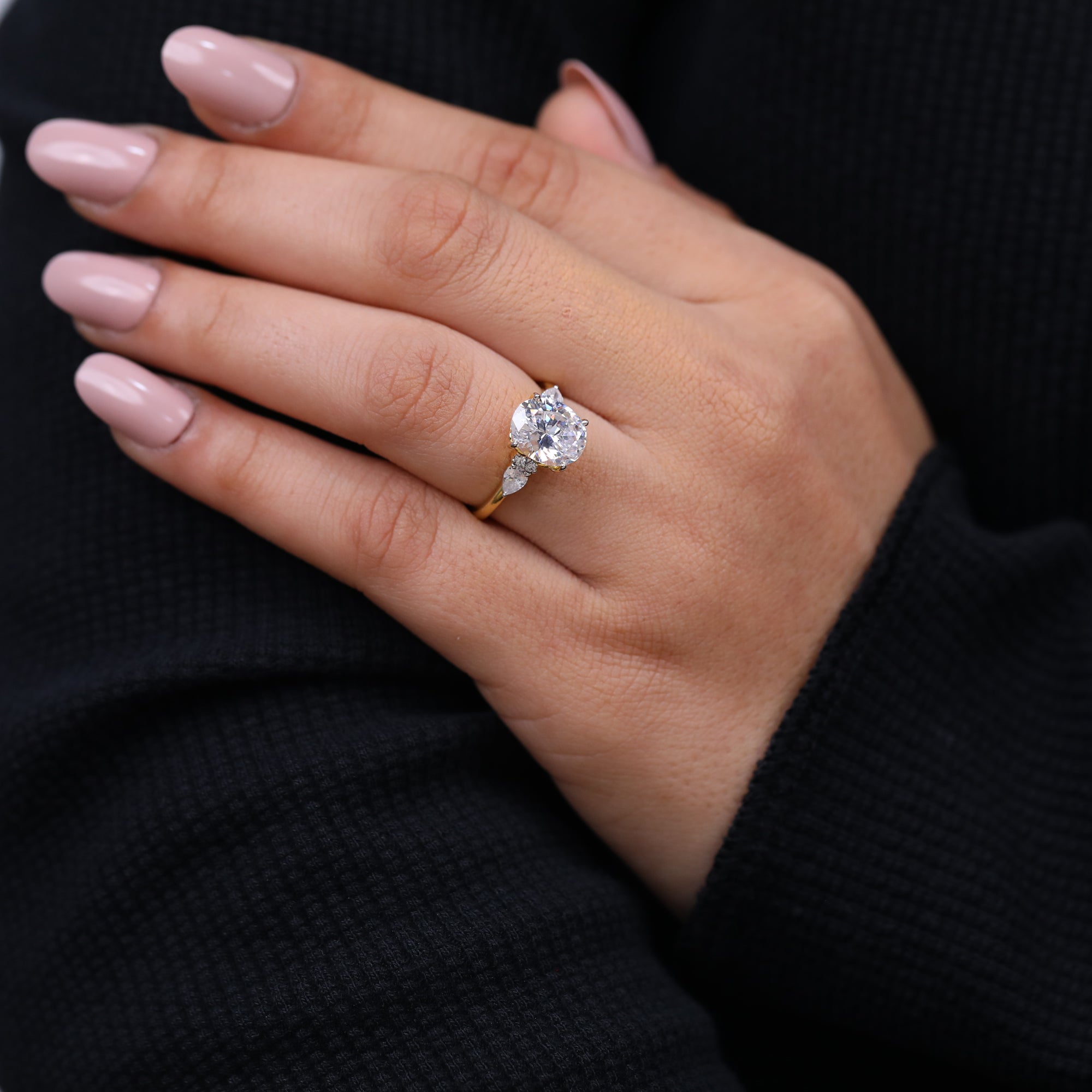 Gold three stone engagement ring with oval lab grown center diamond