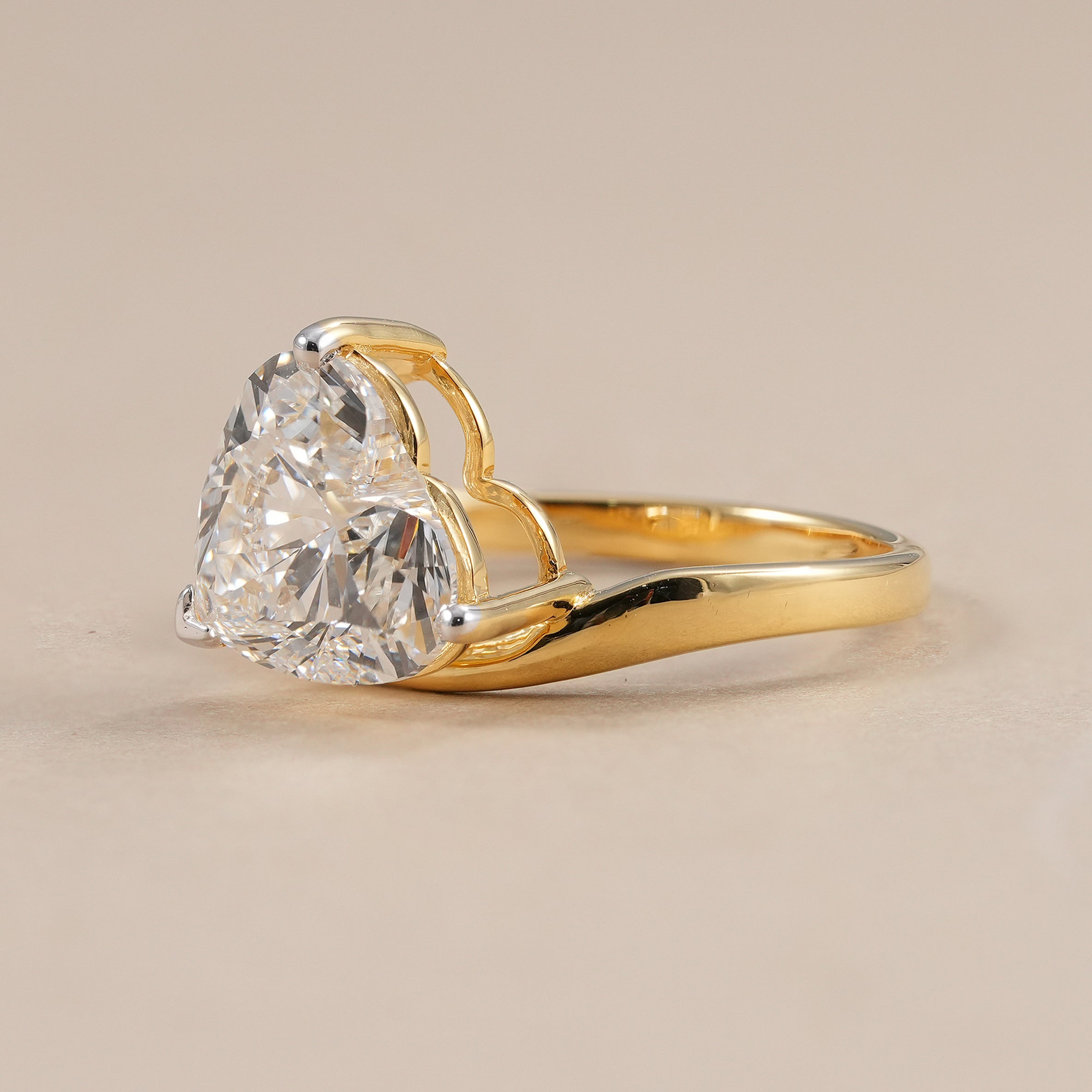 Heart cut solitaire diamond ring in yellow gold curved band setting