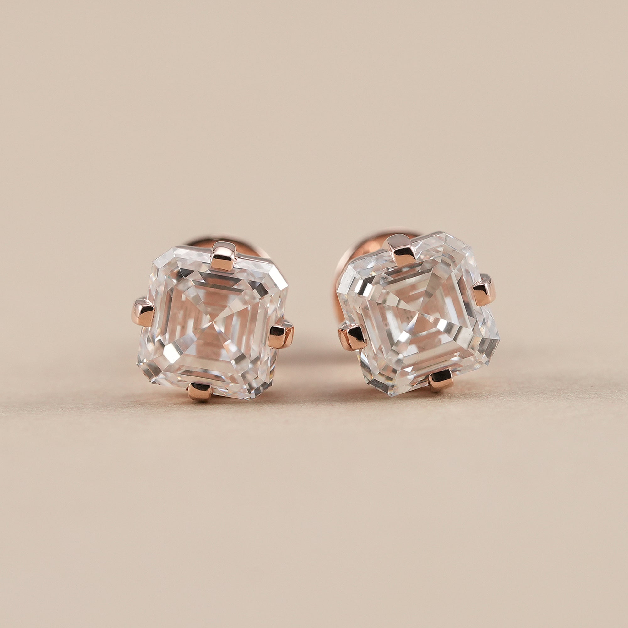 Asscher lab diamond stud earrings featuring IGI certified step cut solitaire diamonds in a classic four-prong setting.