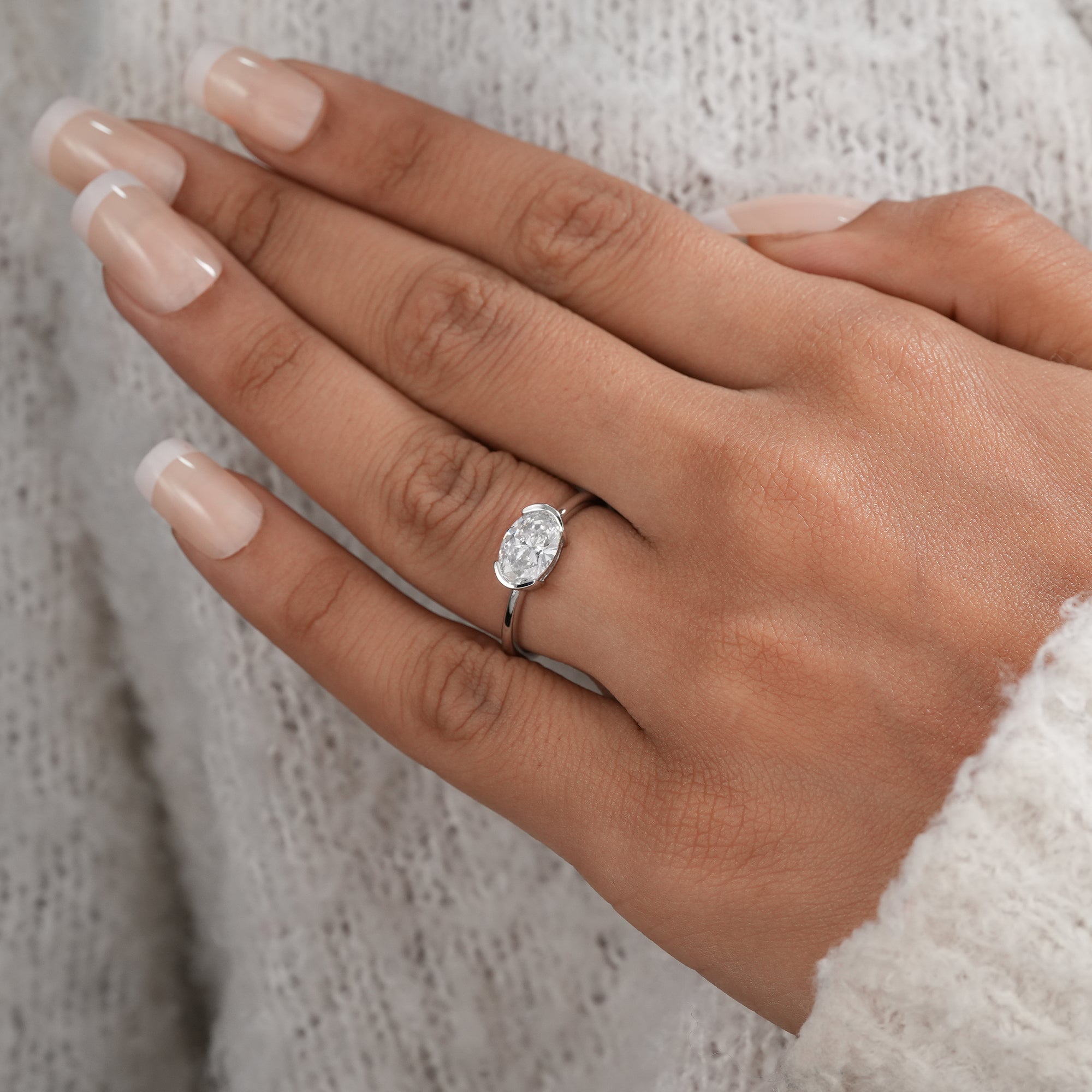 Modern half bezel oval diamond solitaire ring