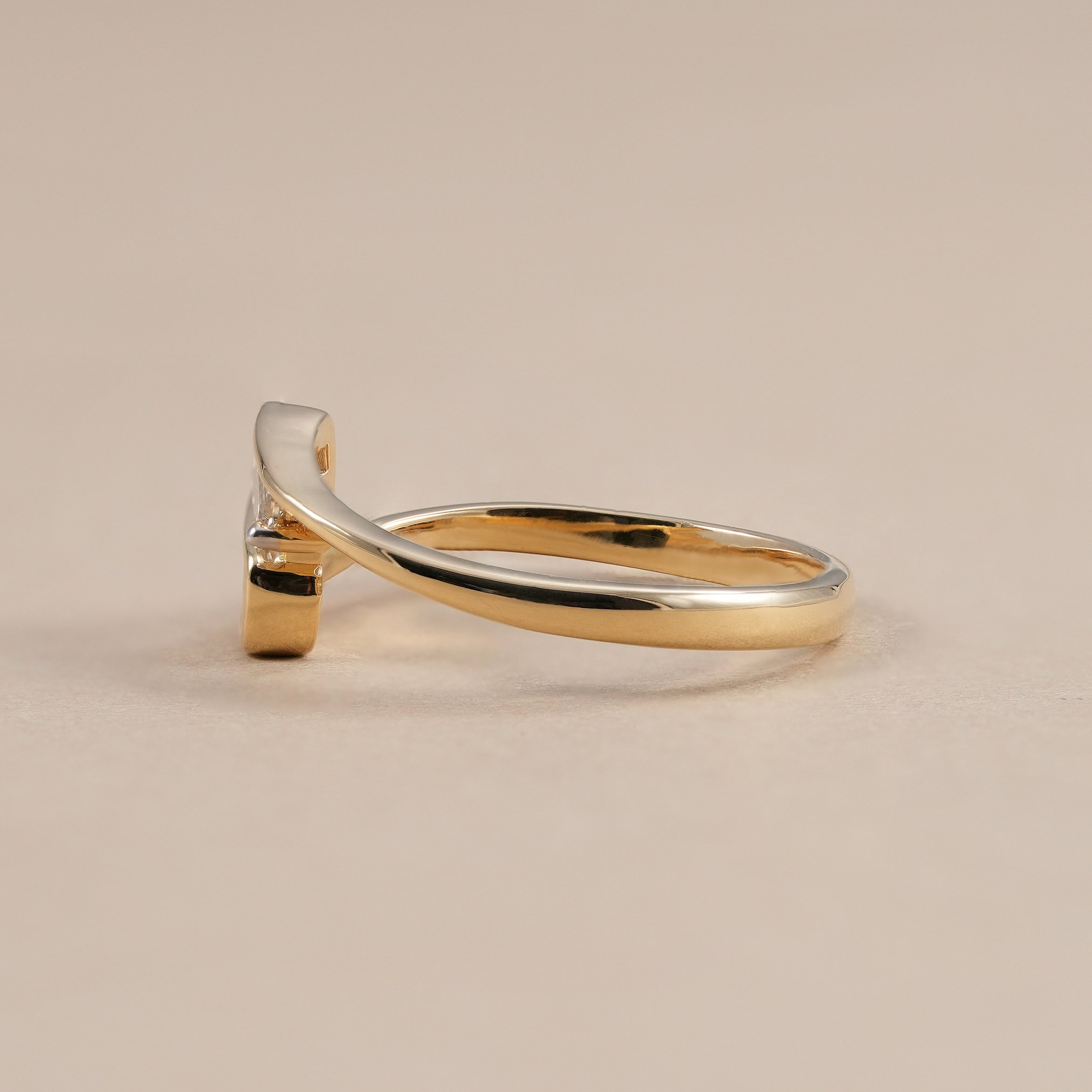 Modern bezel set baguette diamond bypass ring in gold