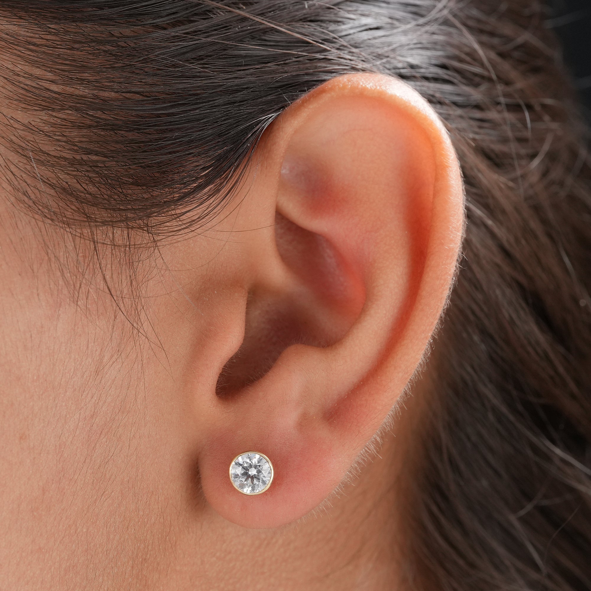Round cut lab grown diamond solitaire stud earrings with bezel setting.
