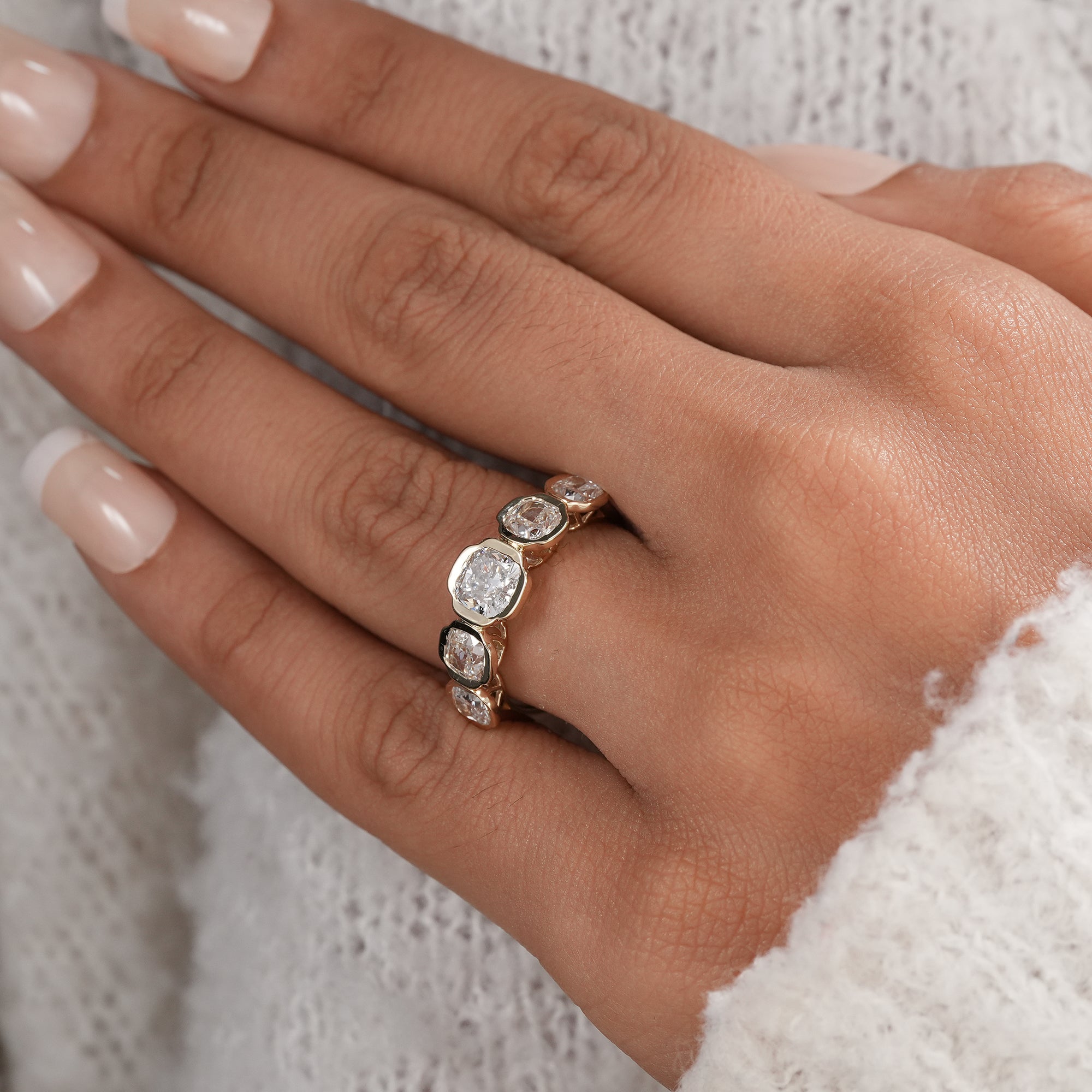 Elegant bezel set cushion diamond band for bridal jewelry.