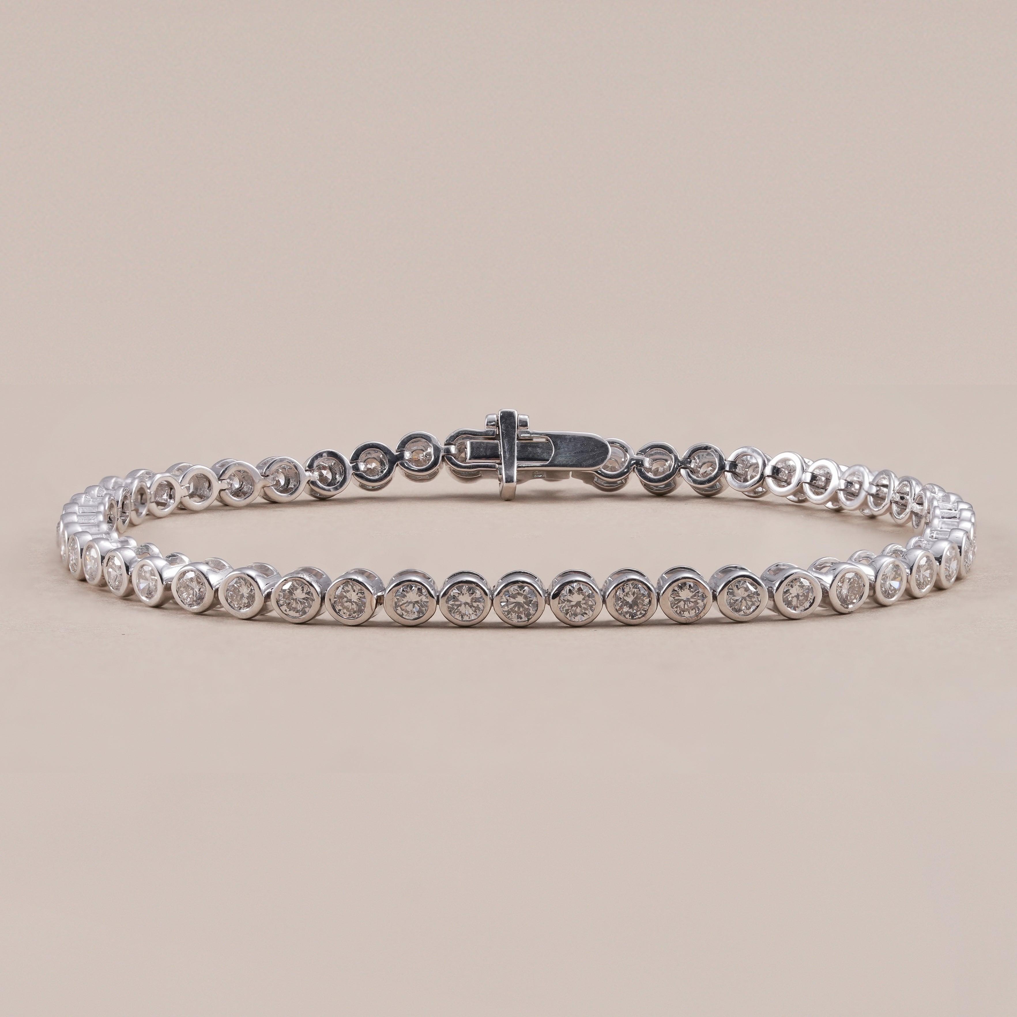 Round cut lab grown diamond tennis bracelet with bezel setting in white gold.