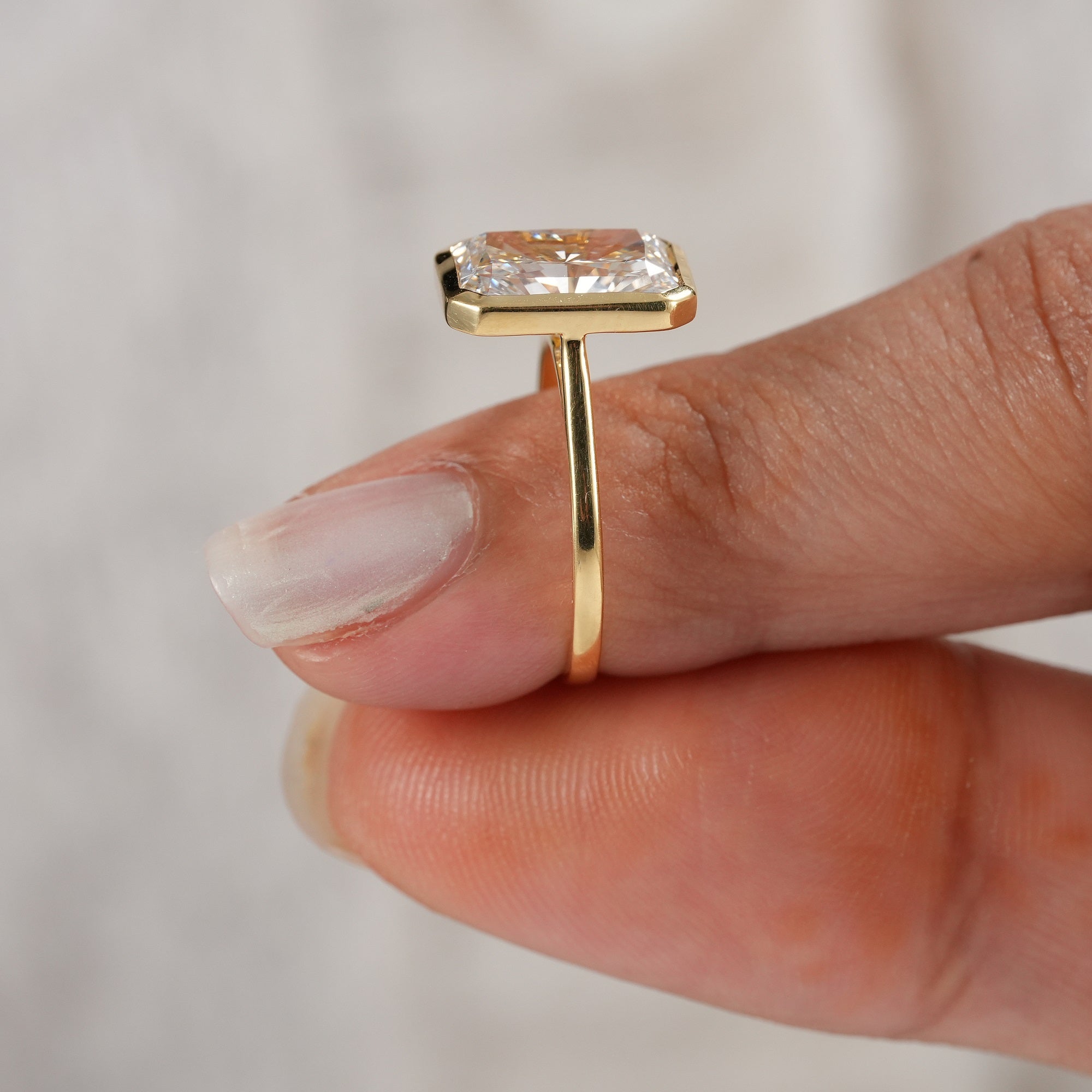 Gold bezel set radiant diamond ring side angle