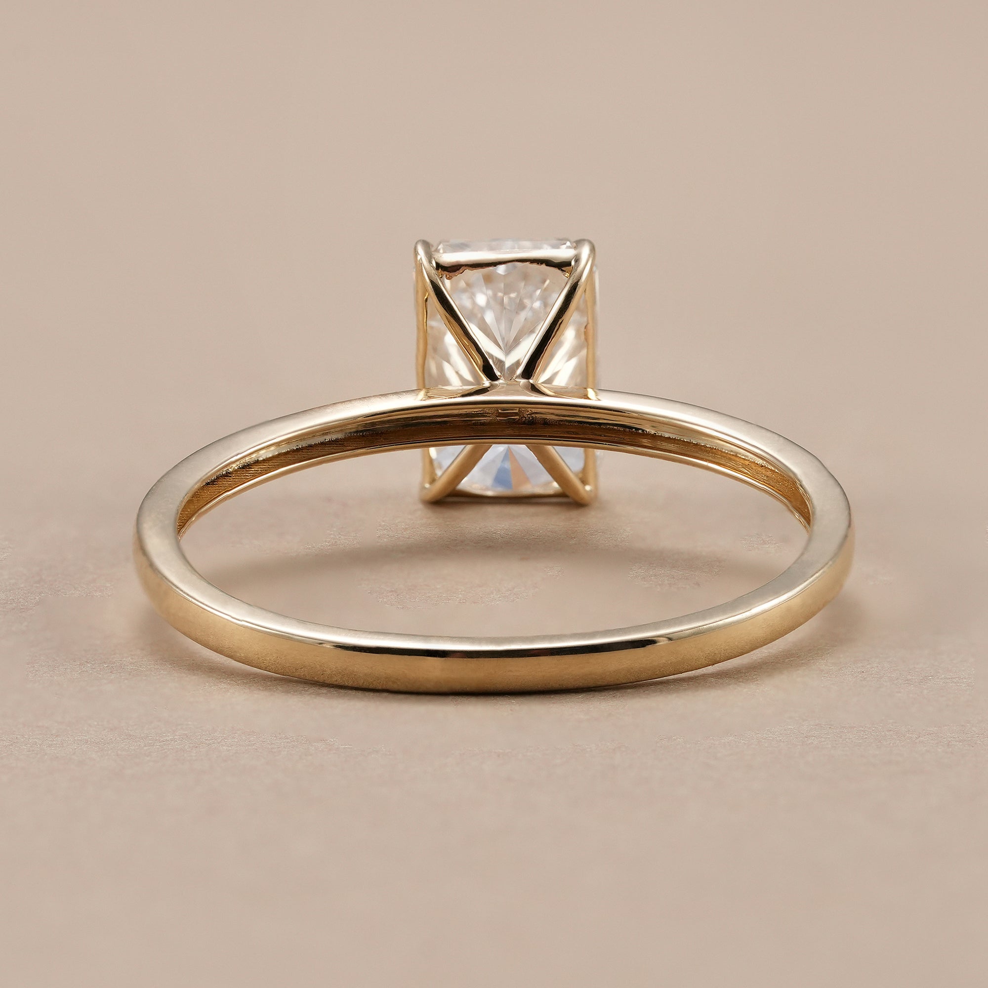 Handmade radiant cut solitaire diamond ring in 14K yellow gold.