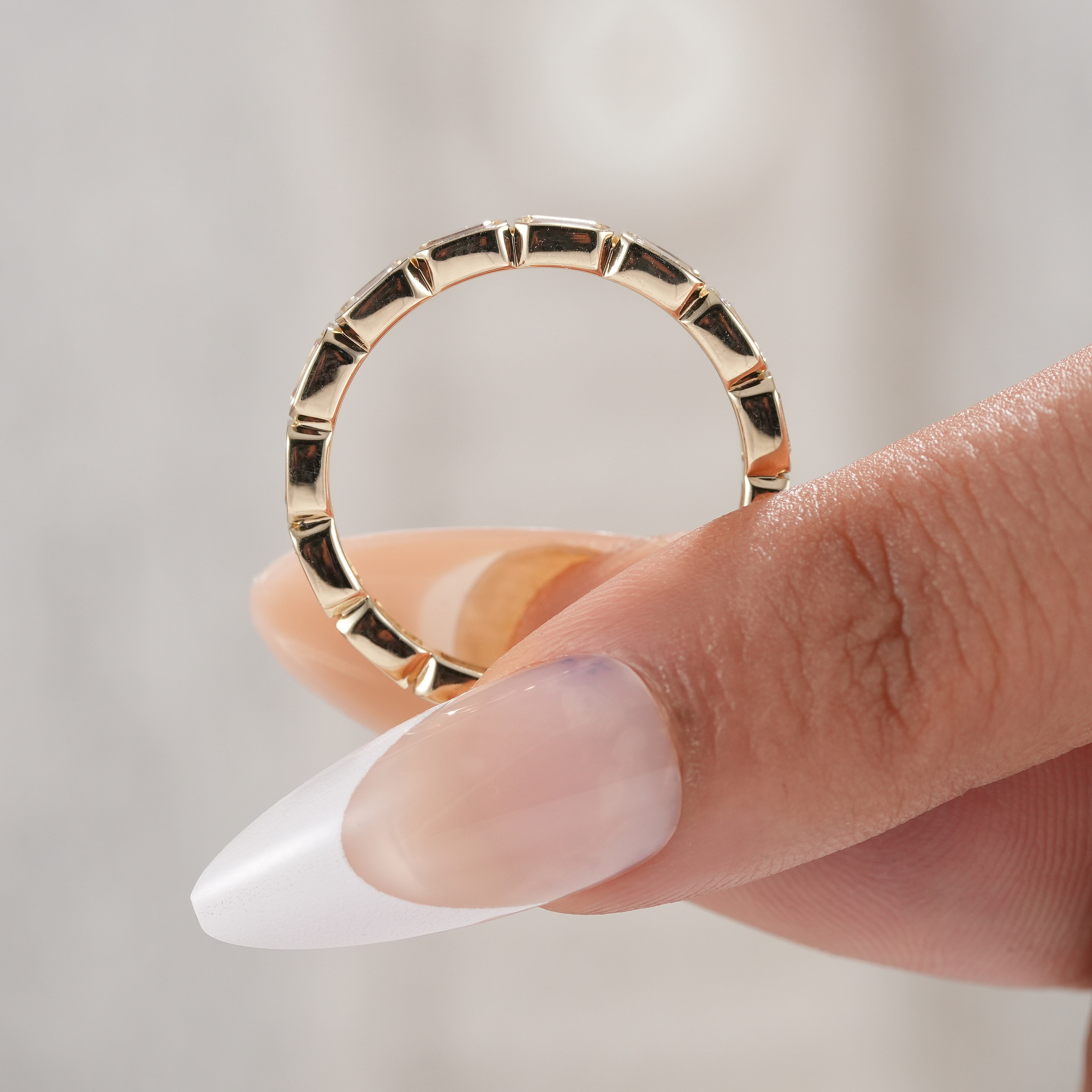 Bezel set emerald cut diamond anniversary band.