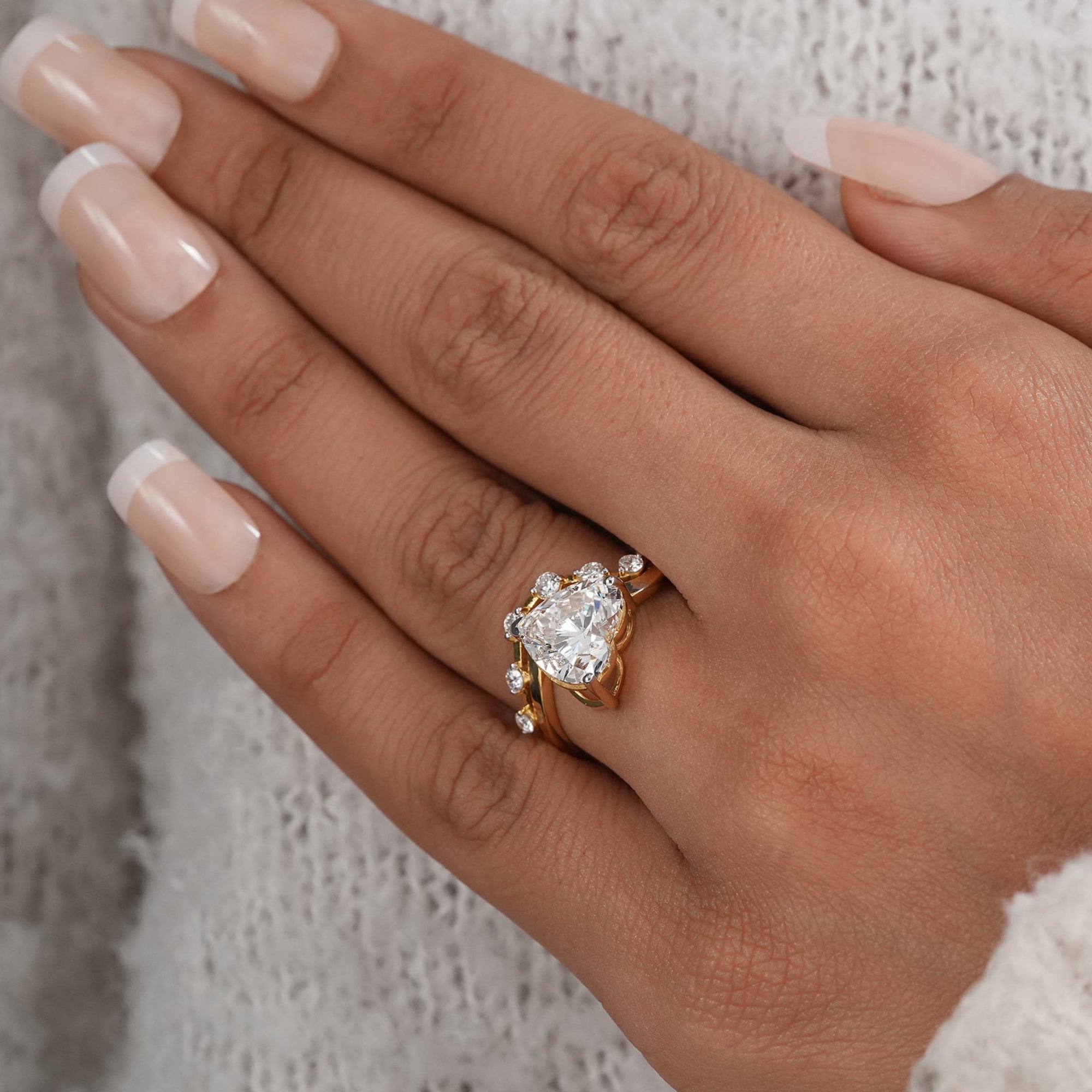 Lab grown heart diamond ring with curved diamond accent band.