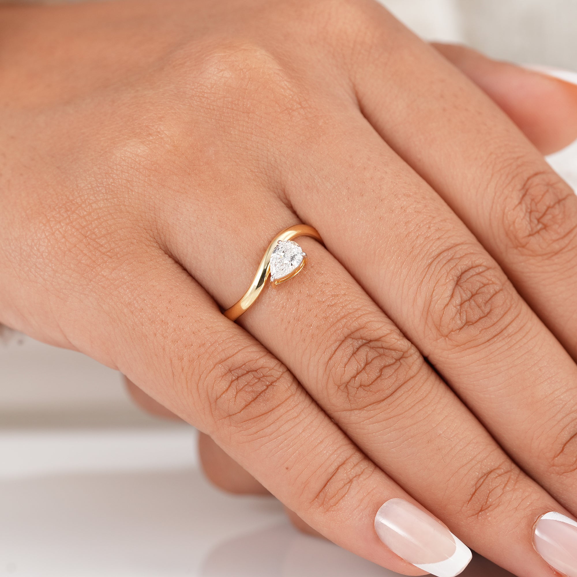 Pear cut engagement ring with wave gold band
