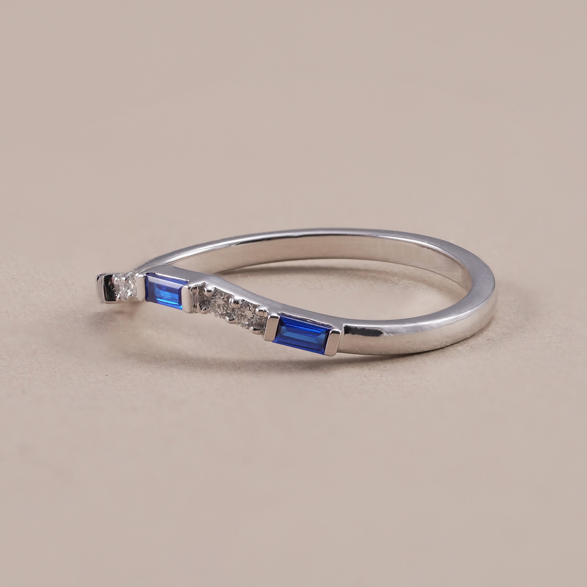 Minimalist curved stacking ring with blue baguette gemstones