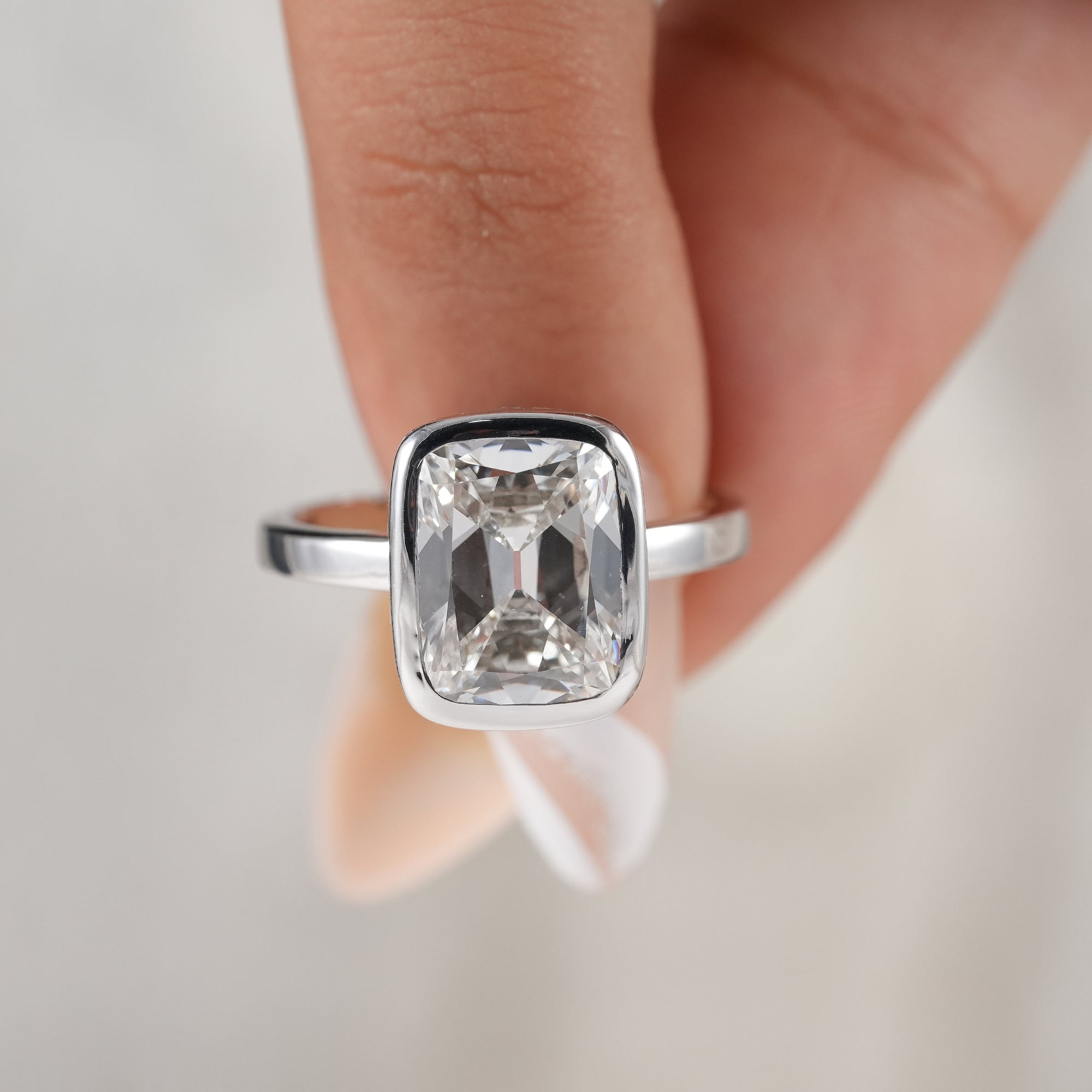 Elegant solitaire cushion diamond ring with hidden halo.
